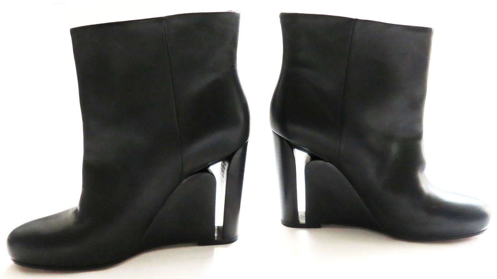 EDITOR'S NOTES:

New MAISON MARTIN MARGIELA Line 22, black leather see-through 'heel-in-heel' detail boots

Cut-out, stilletto heel silhouette within the thick, stacked wooden wedge heels

Signature white tack-stitch detail at rear

White