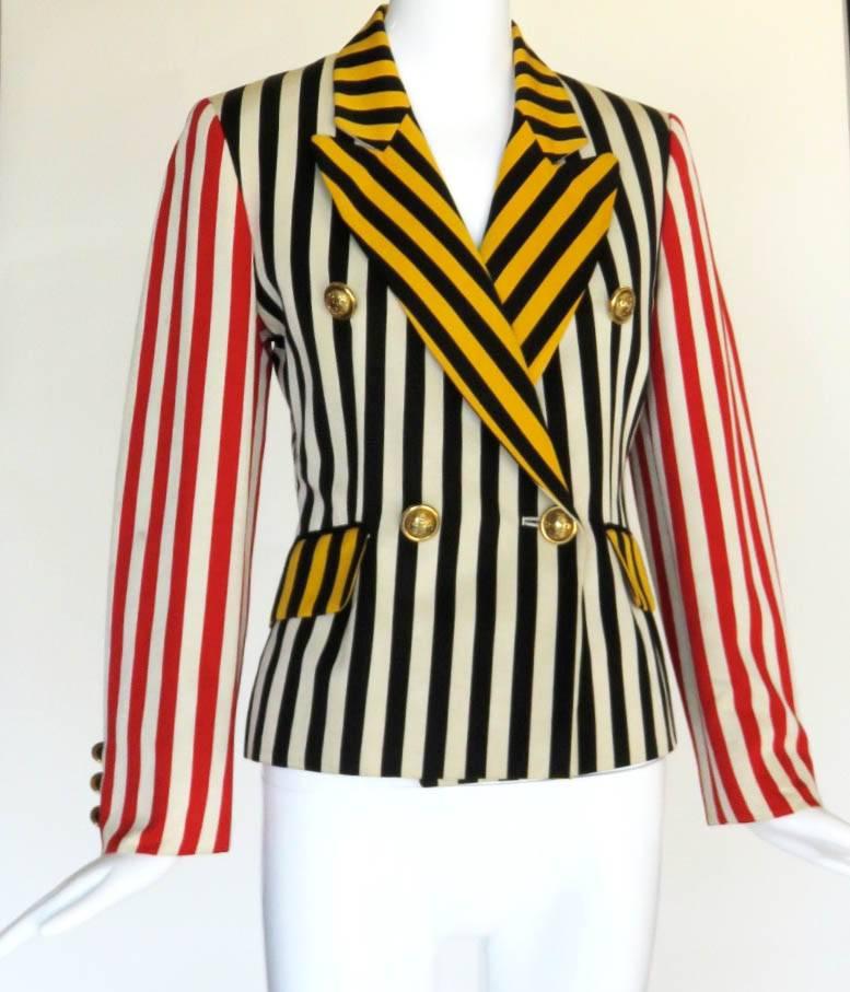 Early 2000's, MOSCHINO striped faille blazer jacket.

Color blocked-style striping design.

Large, metal dome-shaped, cross engraved buttons at double-front closure.

Twin flap pockets at the waist level.

Lined with signature artwork print