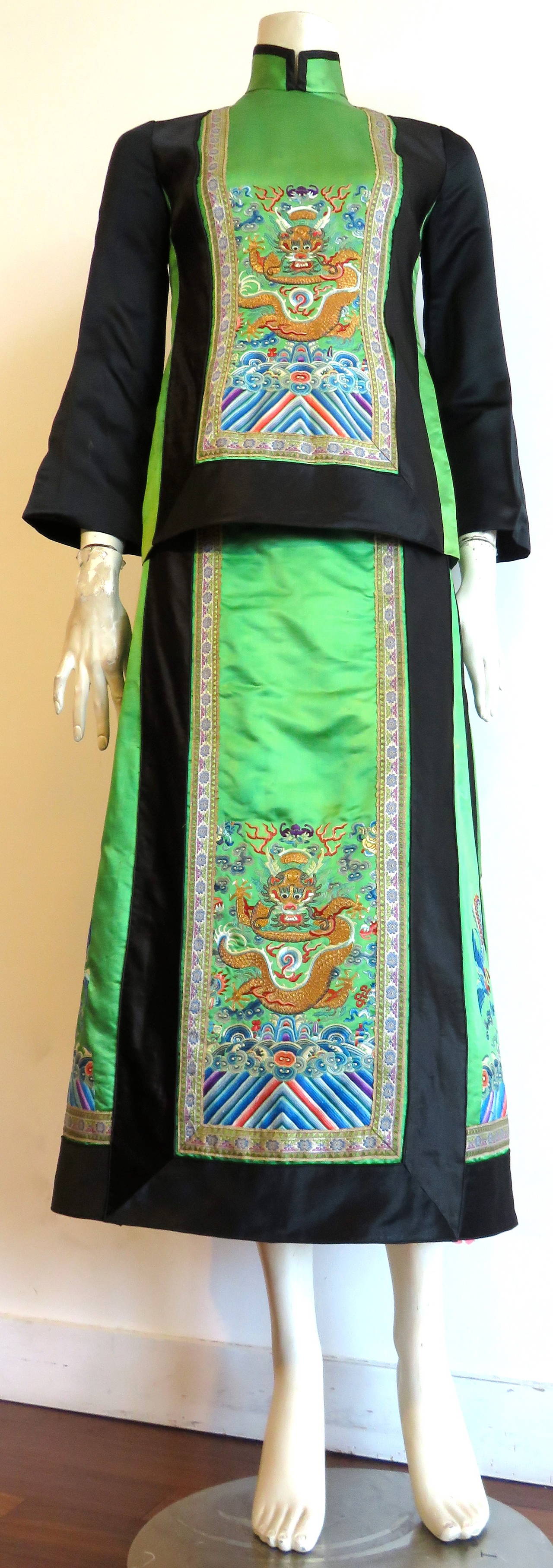 Beautifully constructed Chinese, 2pc., tunic and skirt set in vibrant green, and black silk satin, featuring multicolor embroidery work.

The embroideries, and woven silk fabric were all originally made in China, and the original owner had the
