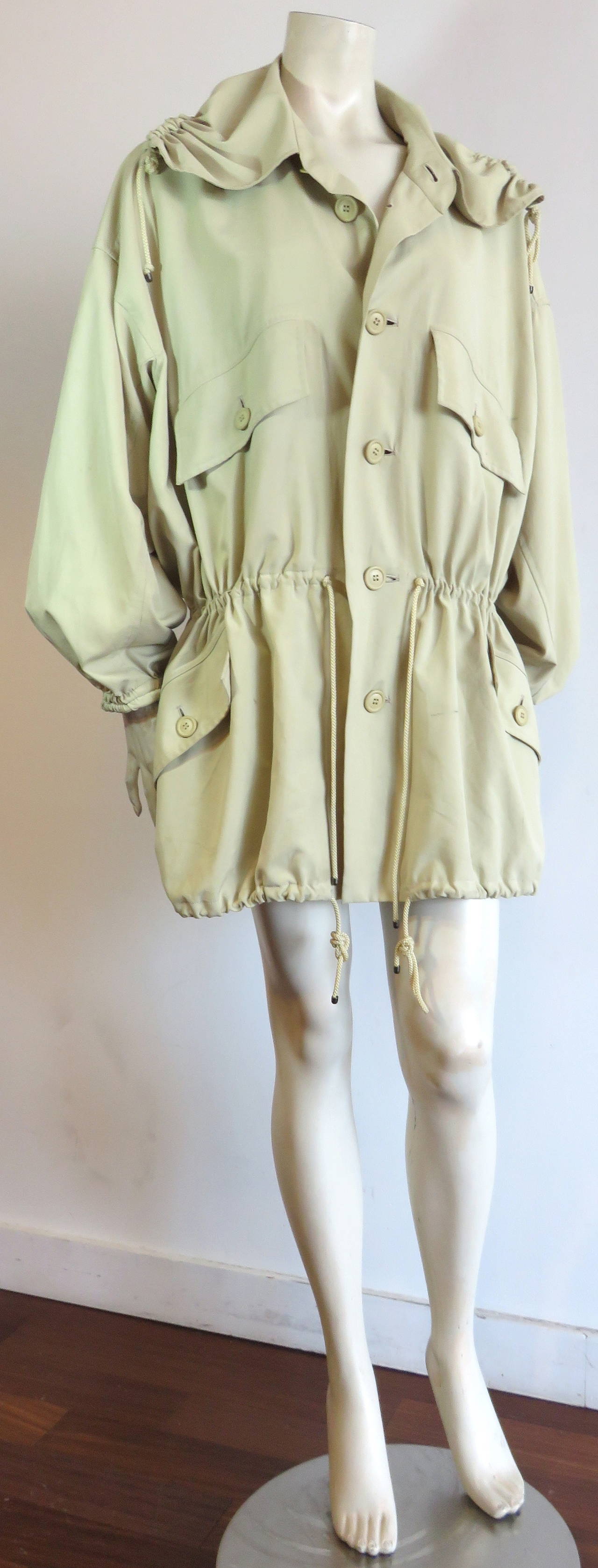 Wonderful, 1980's ISSEY MIYAKE Windcoat in creme/ochre color.

Light-weight silky, micro-fiber, woven fabrication.

Gathered/drawstring construction at hood edge, waist, and bottom hem.  Elasticated sleeve cuffs.

Oversized, loose fit, drop