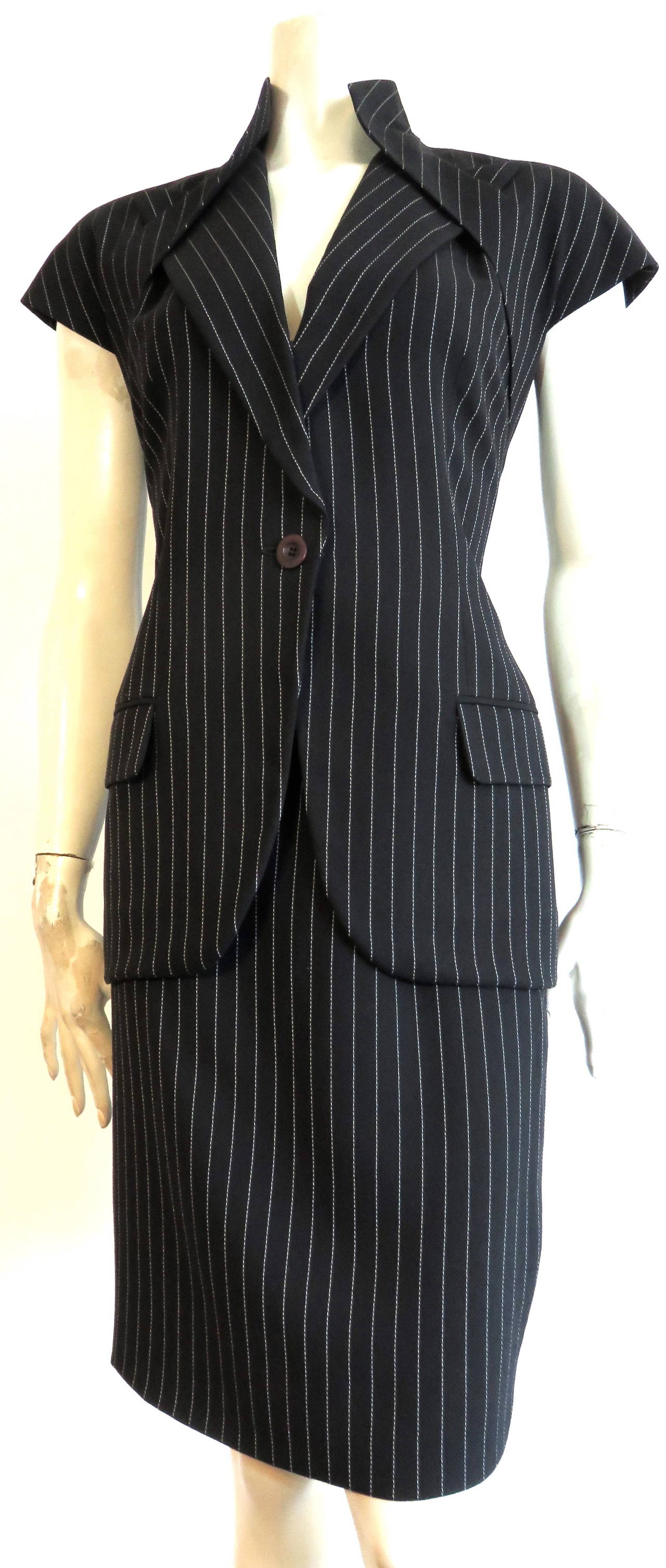 Excellent condition, 1998 GIVENCHY COUTURE by ALEXANDER McQUEEN, pinstripe skirt suit featuring sharp, peak lapel detail.

The jacket of the is incredibly tailored suit, features Alexander McQueen's signature, peak lapel detail which is inserted