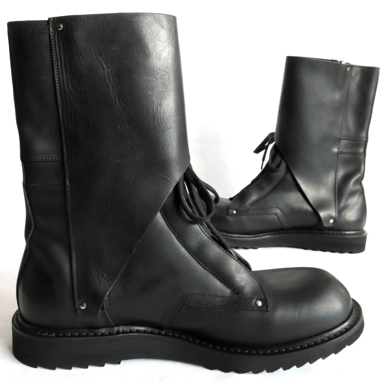 EDITOR'S NOTES:

Excellent condition RICK OWENS black leather combat-style boots

Lace-up style front with side metal zipper entry

Triangle-shaped, storm flap detail with twin straps and metal stud closures

High-quality, italian