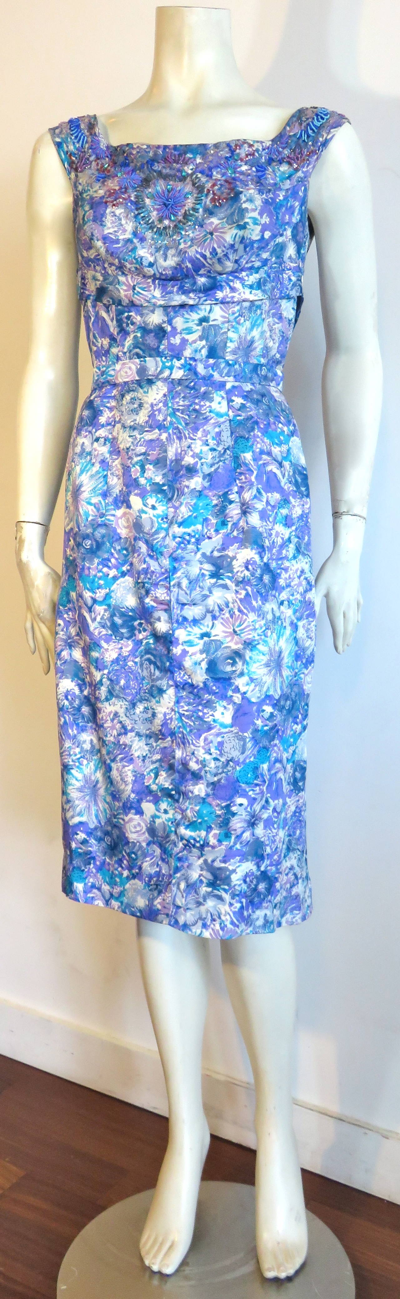 Beautiful, 1950's ADELE SIMPSON, beaded floral silk cocktail dress.

Impressionistic, painted floral artwork in tones of white, lavender, periwinkle, and turquoise printed onto super-soft, lightweight silk twill fabrication.

Gorgeous