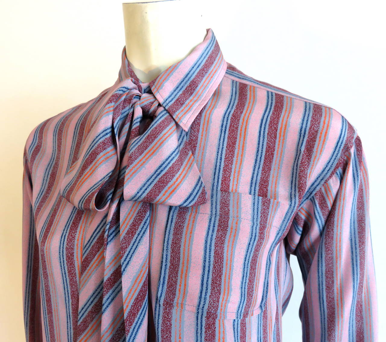 1970's YVES SAINT LAURENT striped silk shirt & matching scarf.

Burgundy, tangerine, navy, and turquoise, crayon-style striped artwork onto mauve ground.

Lightweight, silk fabrication.

Pop-over style silhouette with button placket down to