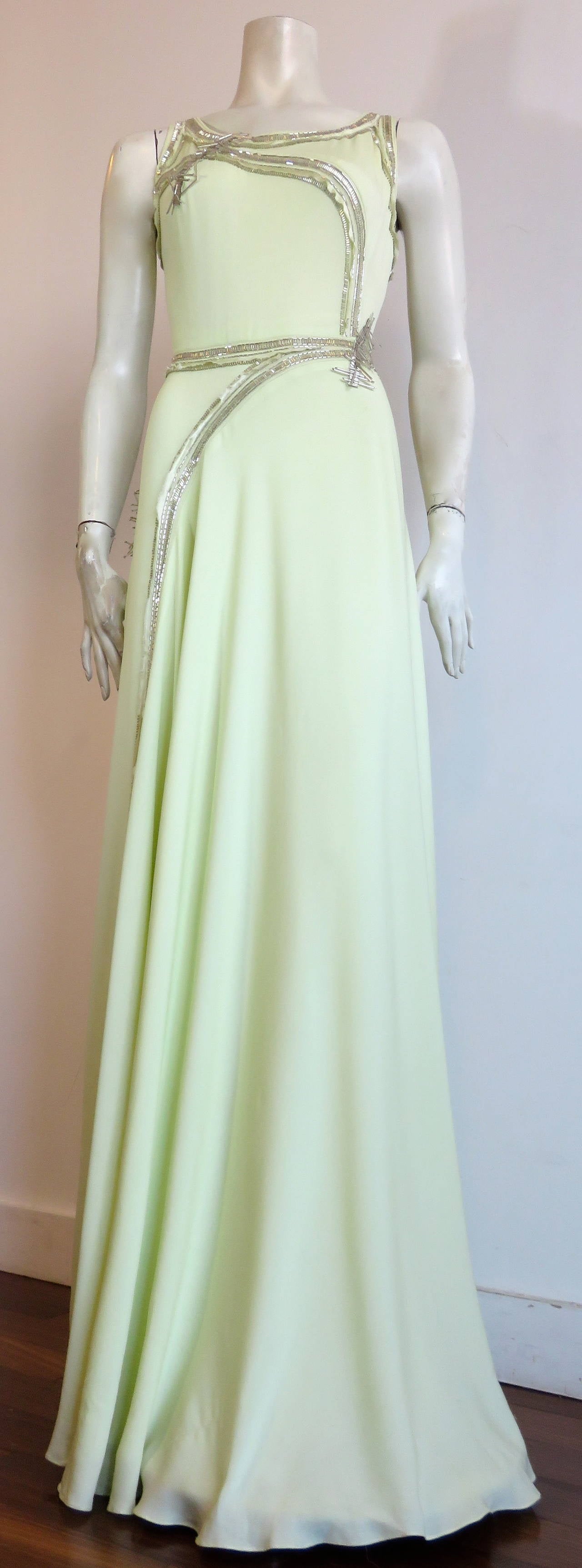 New with tags, CAROLINA HERRERA, embellished silk evening dress.

Beautiful, jade-frost color, silk crepe shell with opulent, platinum-tone, hand beadwork.

Gorgeous, statuesque silhouette.

Regimented cylindrical beading with raw-edged, silk