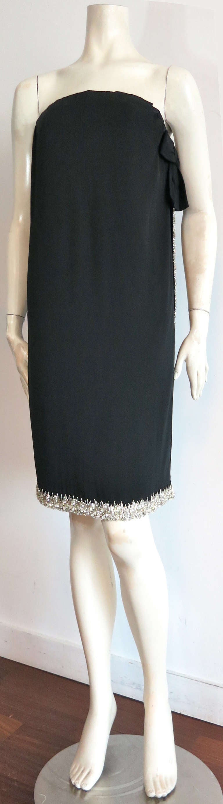 1965 CHRISTIAN DIOR Haute Couture Numbered black silk dress.

This elegant, haute couture dress was designed by Marc Bohan for the house of Dior in France for the Spring of 1965, and is numbered '126870'.

The dress is made of black silk crepe,