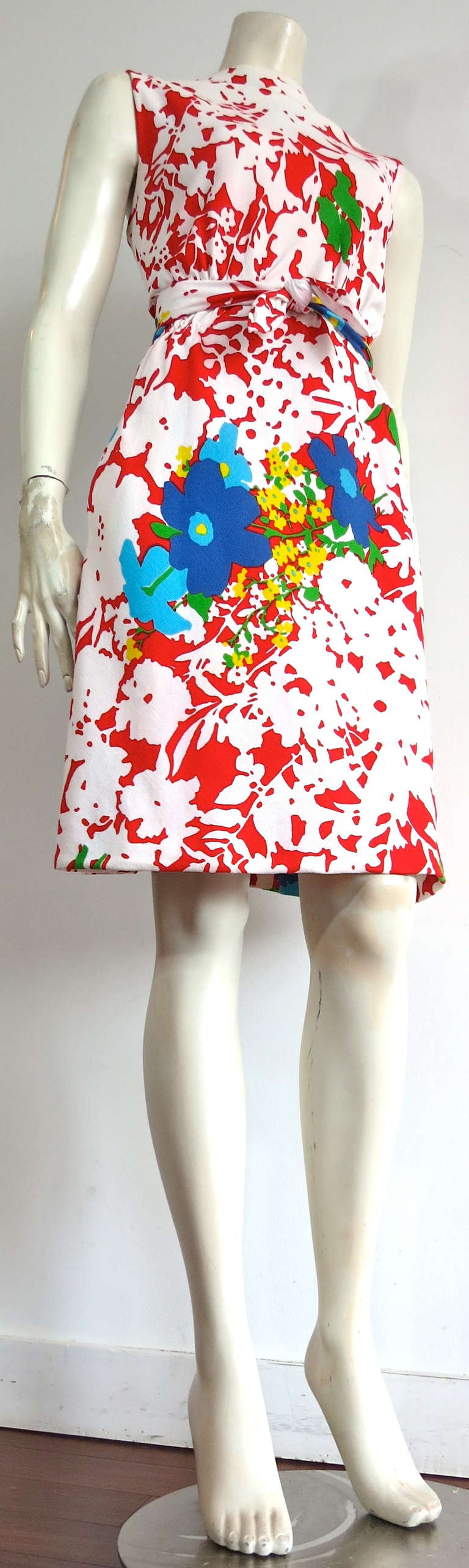 Vintage PAULINE TRIGERE Floral print dress.

This adorable, colorful dress was designed by Pauline Trigere during the 1960's, and is made in the USA.

The red and white floral base artwork features multi-color 'bouquets' throughout the