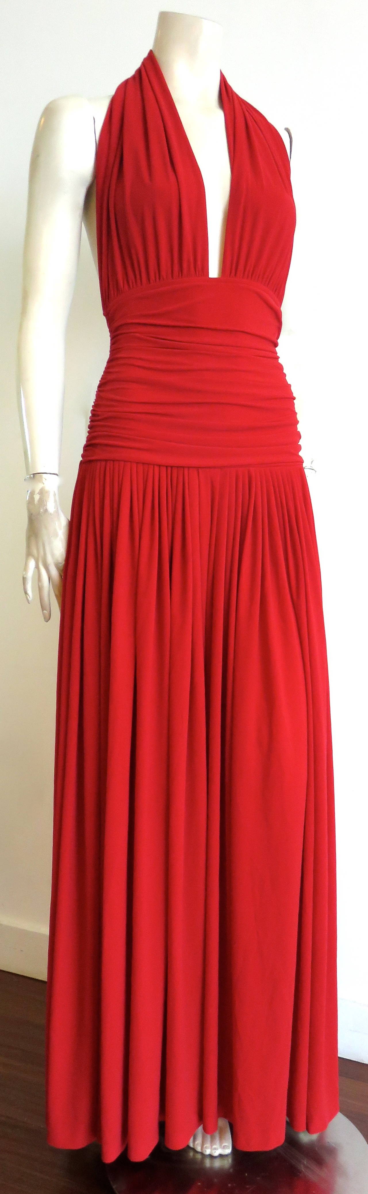 Amazing, early 1980's NORMA KAMALI OMO, 'Bill' halter-neck palazzo jumpsuit in scarlet red.

Plunge neck front opening with ruchéd waist panel.

Open back design.

Very wide, palazzo style, bottom pant legs, which appears like a full dress