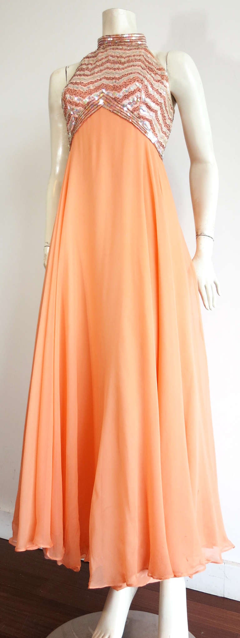 1960's MALCOLM STARR attributed silk empire dress & evening cape set in apricot color, silk chiffon fabric.  

This stunning dress features zig-zag, chevron detailing at the top, empire bodice with sequin and cylinder beading.  The neck features