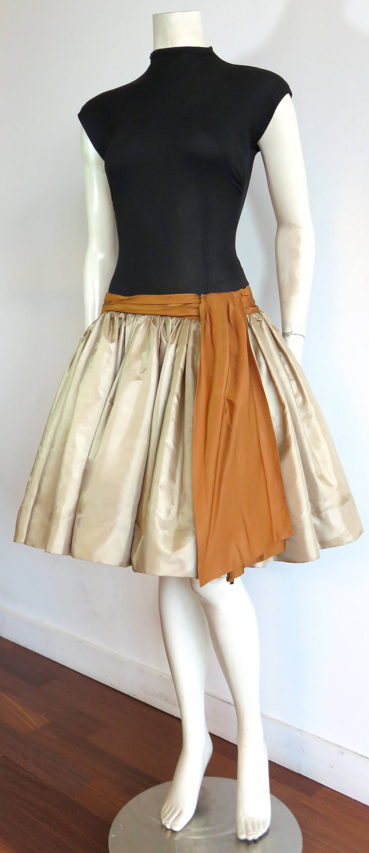 1950's SUZY PERETTE Bouffant cocktail dress inspired by Christian Dior's New Look.

This adorable dress features a wonderful color combination with a golden taffeta full skirt, and bronze sash detail. 

Dropped, fitted waist silhouette with
