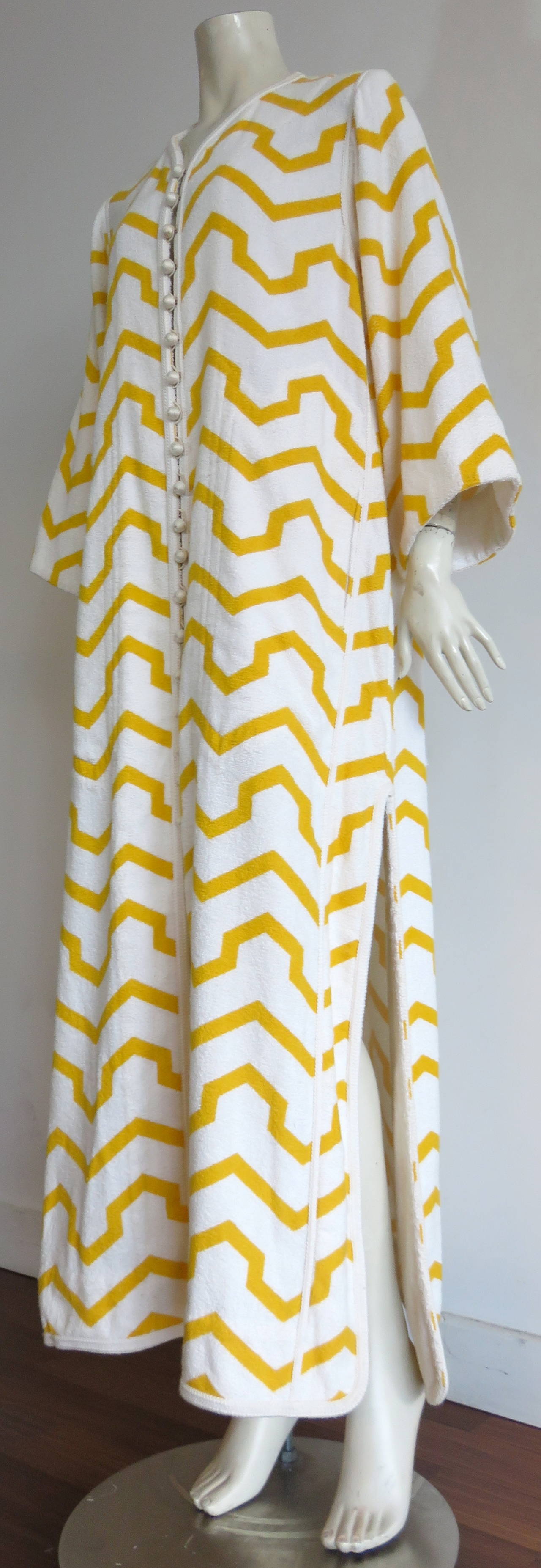 Excellent condition, 1970's GIVENCHY Couture, golden yellow, chevron-striped caftan/robe.

White, cotton, french terry base cloth fabrication with Moroccan-style, white braided trims, and thread-spun, ball button closures at front
