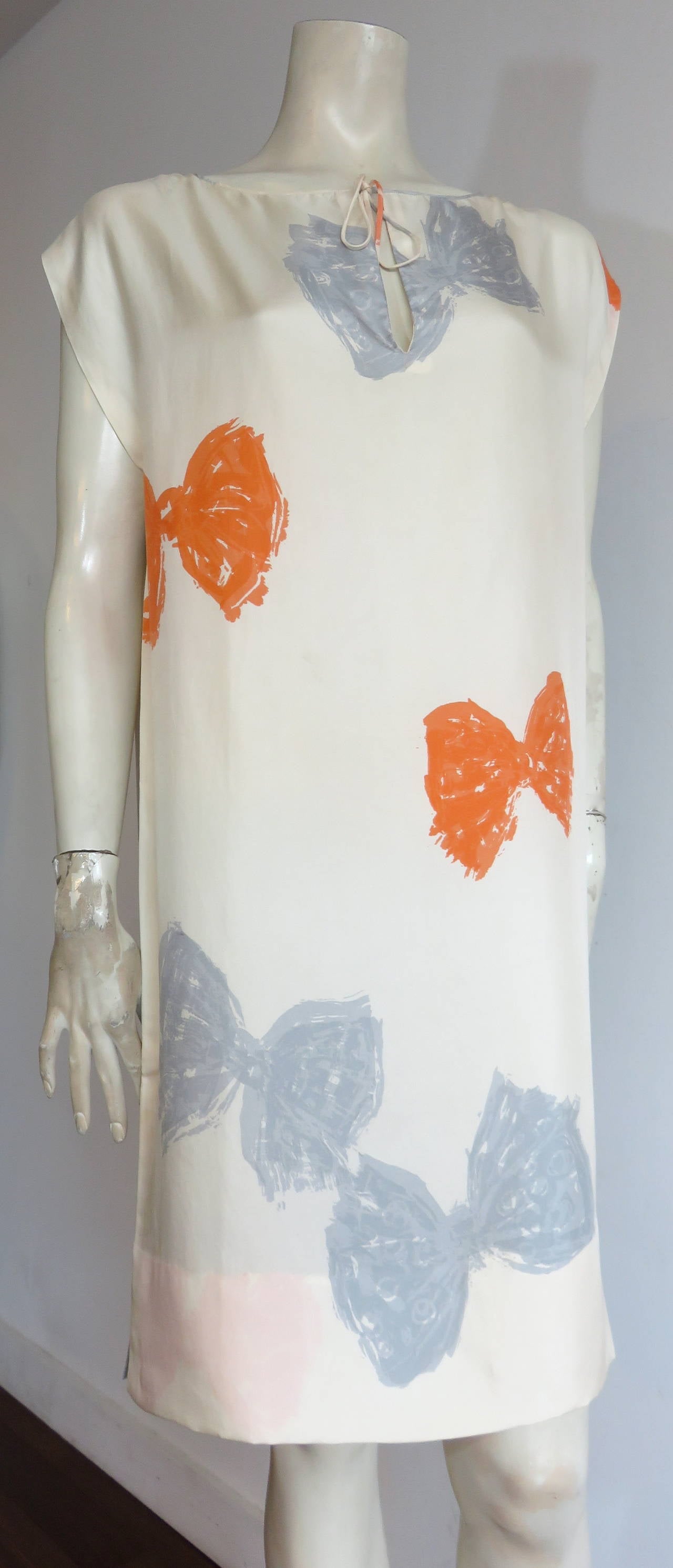 Excellent condition, 1960's, BALENCIAGA haute-couture, silk scarf, tunic dress.

This lovely tunic dress features an all-over, painted-style, bow print artwork in tangerine, and gray/blue, atop creme-tone silk.  

Silk scarf-style fabrication