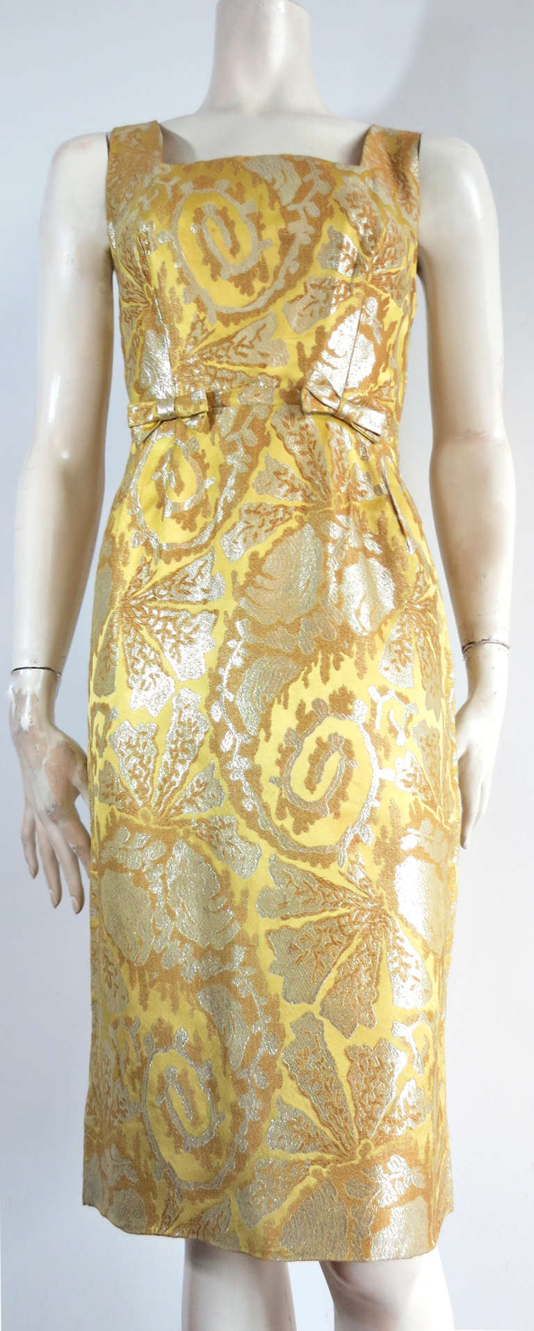 1960's Metallic brocade cocktail dress.

This luxurious cocktail dress is made of a gorgeous, woven silk brocade with a chartreuse satin ground, and metallic platinum tapestry artwork.

Twin bow-tie detail at front waist with square-neck, front