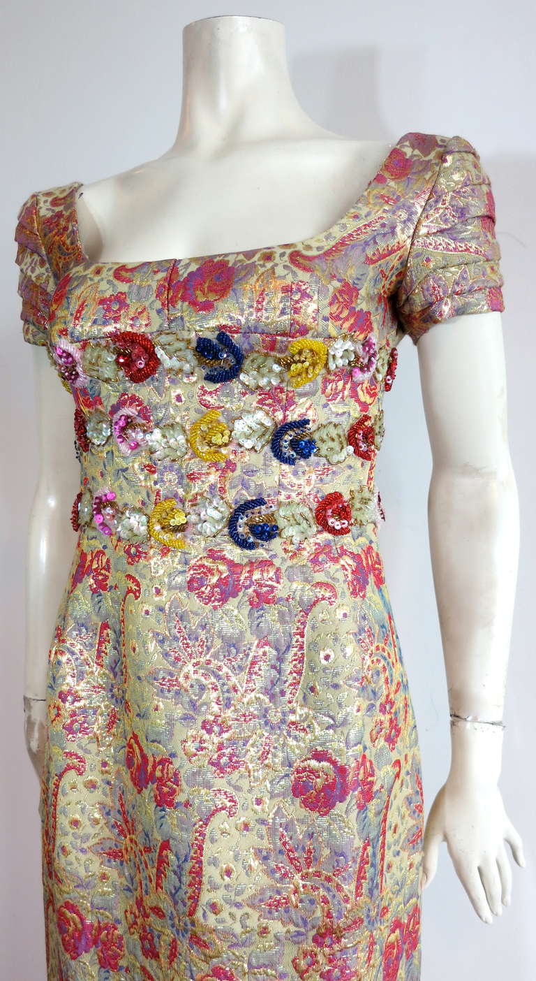 This stunning dress was designed by Karin Muller-Wohlfahrt during the 1980's in Germany.

Exceptional dress construction with opulent, multi-color & metallic gold floral brocade fabrication.

Exquisite, jewel-tone, hand-beading, and iridescent