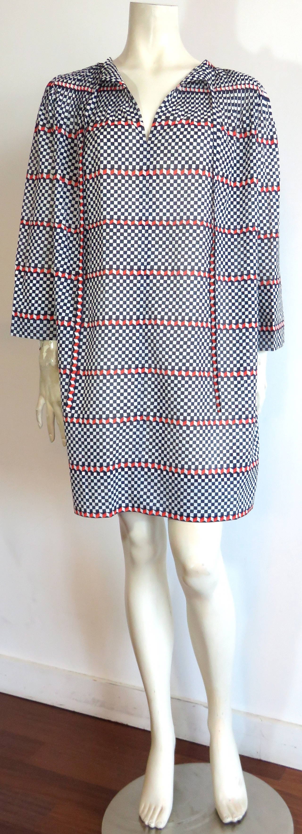Never worn, 1970's GIVENCHY Haute Couture cotton/silk check tunic.

This fabulous tunic features dark, navy-blue, white, and dark, tangerine checked, artwork print, with regimented chevron style stripes within the pattern.

The top, shoulder