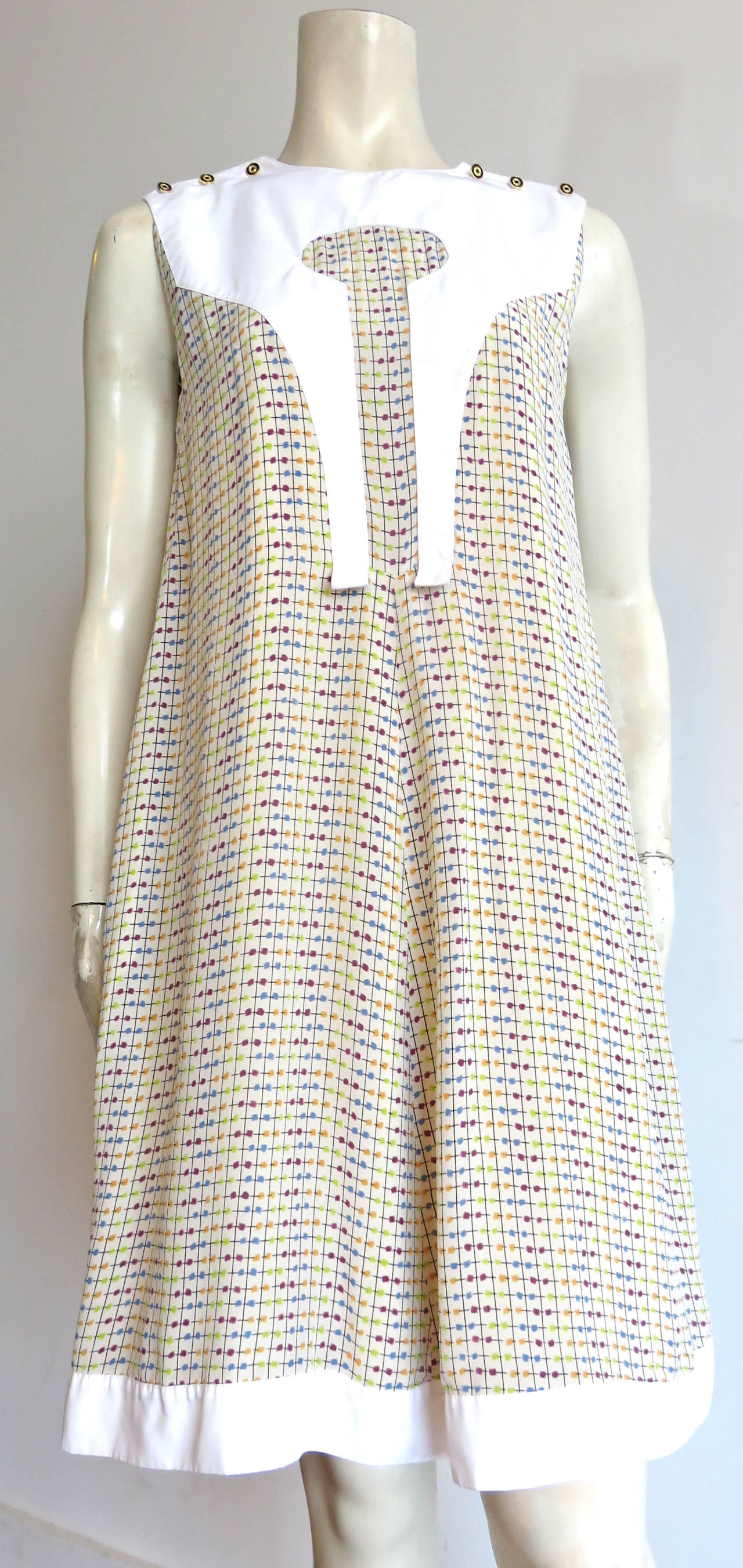 Excellent condition, FENDI, printed silk crepe, 'A'-line, flared shift dress with solid white, block paneling.

Novelty, enamel and metal shoulder button through detailing.

Printed silk crepe fabrication featuring multi-color, check grid