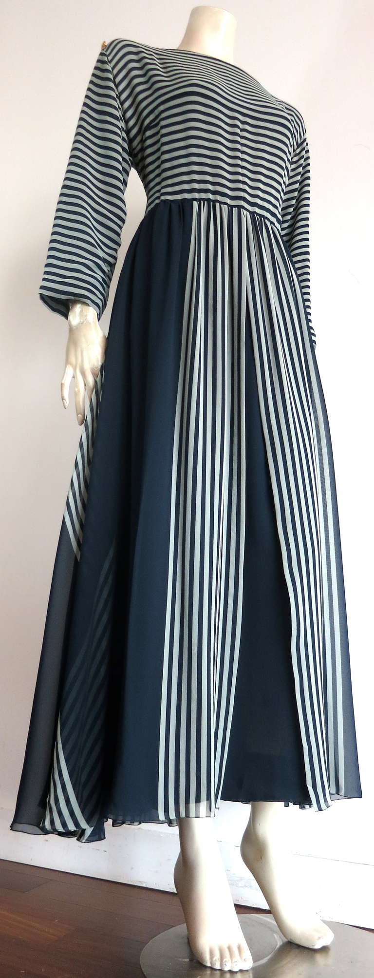 Vintage CHANEL Navy silk stripe dress.

Gorgeous CHANEL 1980's era silk chiffon dress featuring navy and whisper gray printed stripes.  

The top bodice of the dress features a boat neckline with 'CC' monogram logo engraved, gold finish metal