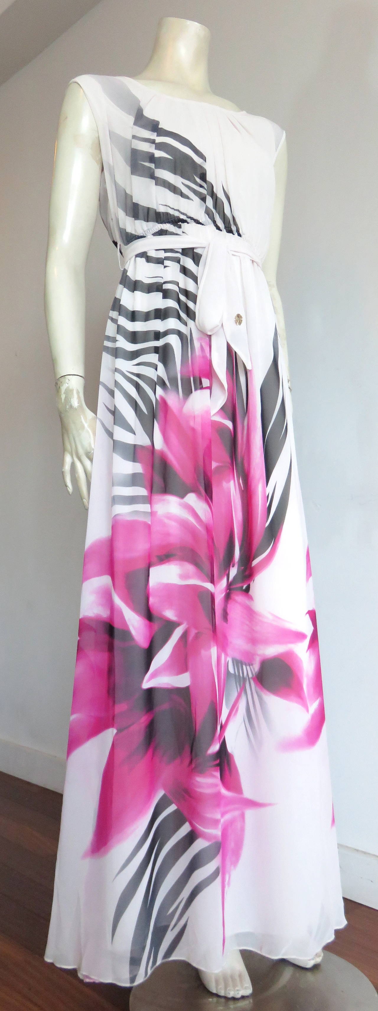 New with tags, ROBERTO CAVALLI, Zebra flower silk dress.

Gorgeous, white silk chiffon fabric base featuring air-brush style flower and zebra stripe artwork at front and back.

Matching waist sash with metal logo detail at end.

Solid,