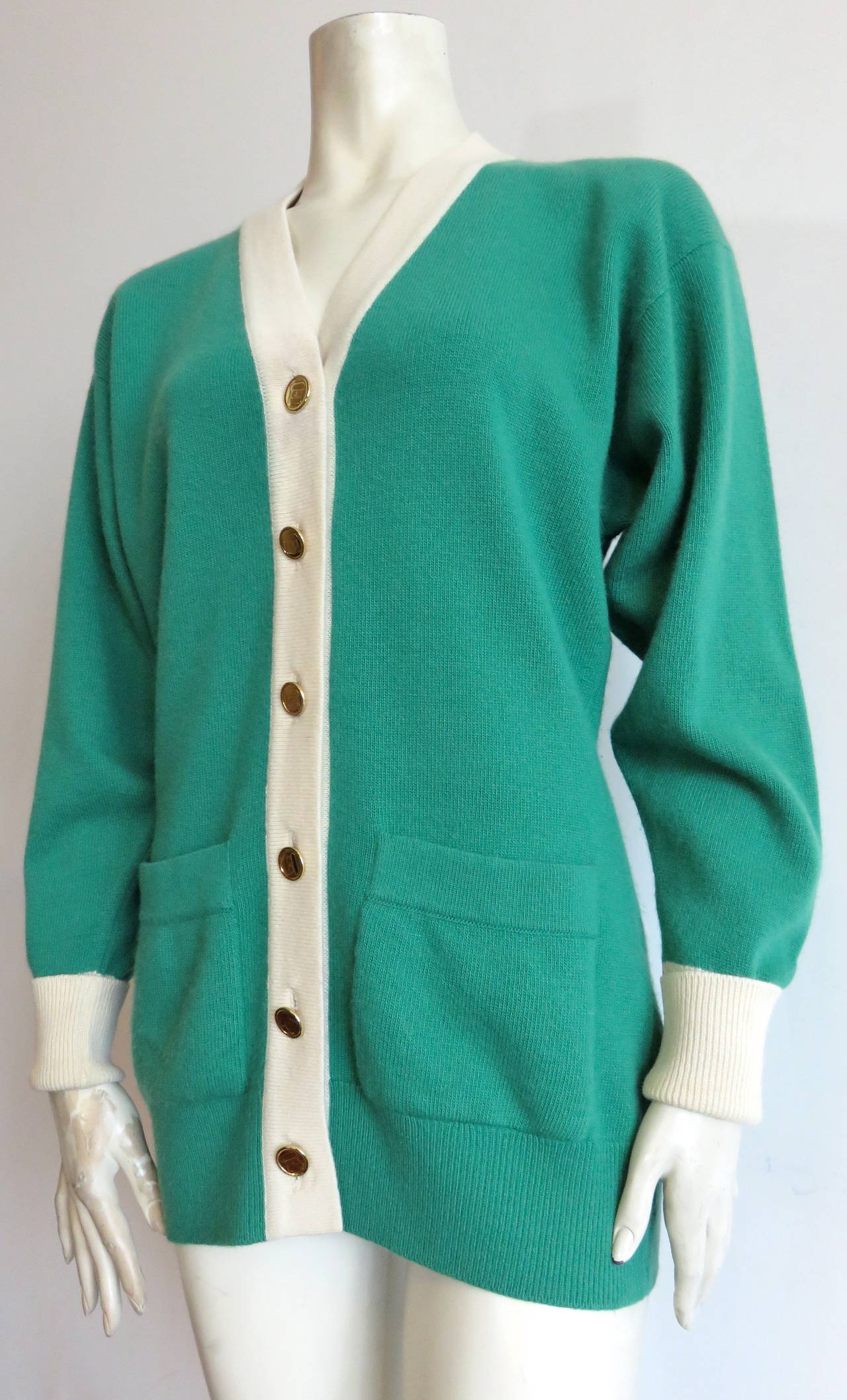 Excellent condition, CHANEL PARIS, pure cashmere cardigan jacket with novelty, 'CC' purse logo engraved buttons.

Luxuriously soft, knit cashmere fabrication in a beautiful shade of green and ivory.

Longer-length silhouette with six button