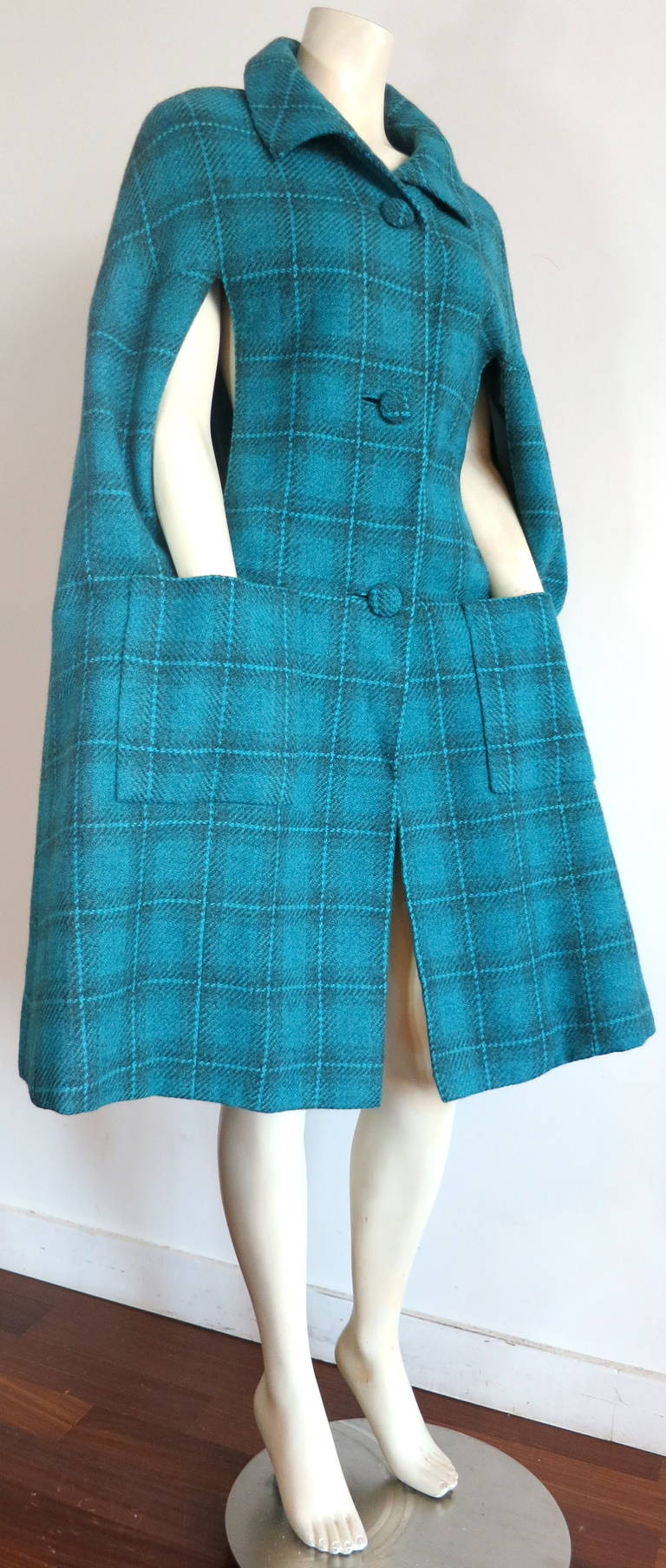 Excellent condition SYBIL CONNOLLY Irish tweed plaid cape coat.

This beautiful cape was designed by Sybil Connolly during the 1950's in Ireland, as labeled.

The beautiful turquoise color is very vibrant and clean.

The cap features triple