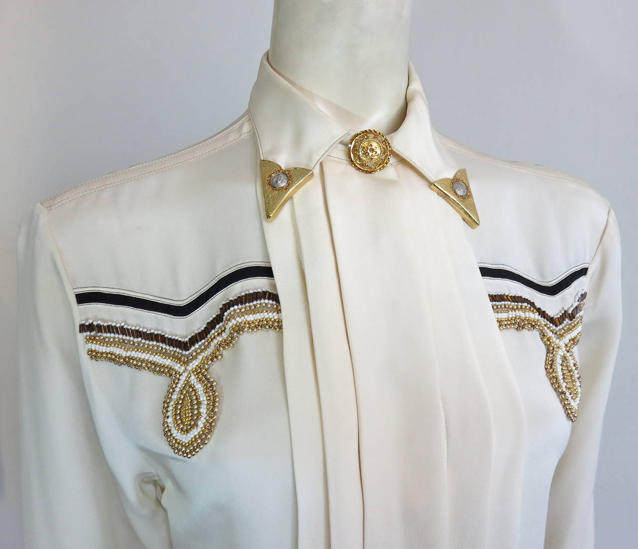 1992 GIANNI VERSACE COUTURE Beaded silk western shirt.

Stunning, 'Medusa' logo engraved metal hardware collar tips encircled with genuine, mini-crystals.

Dazzling, metal and crystal buttons at the front neck, and cuffs.

Pure, ivory silk