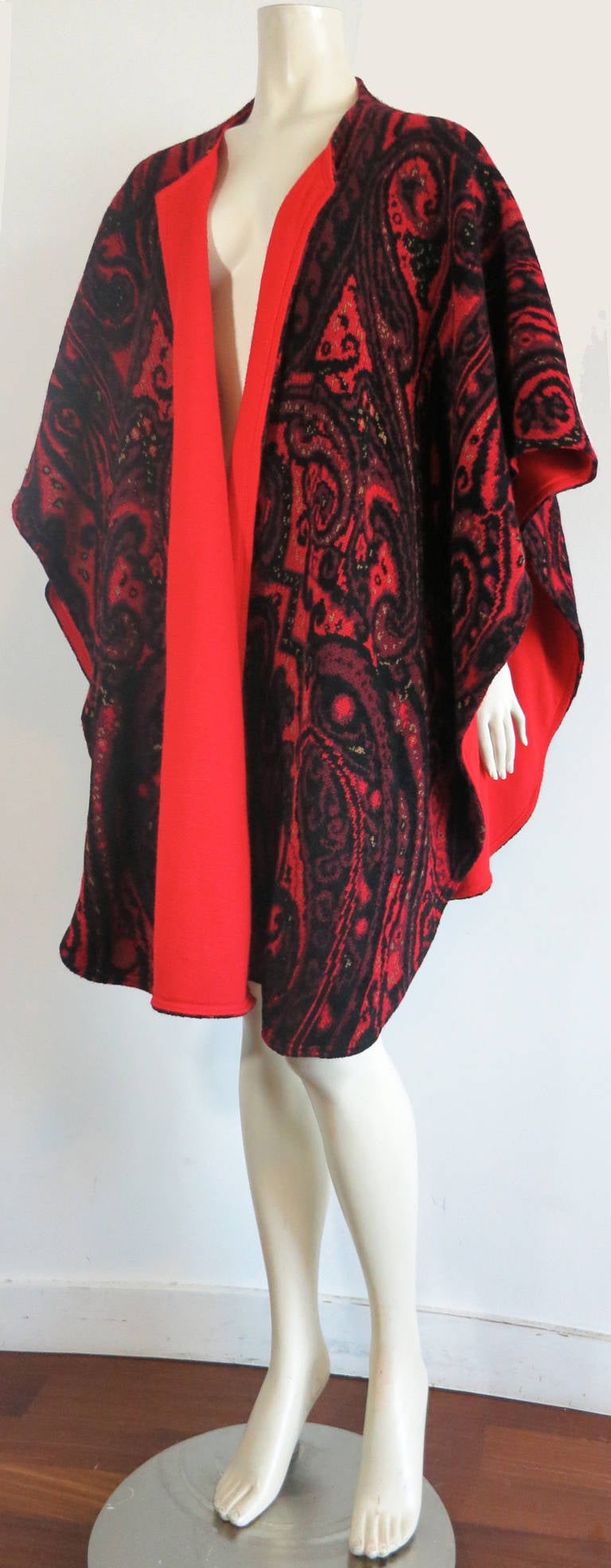 Fabulous, 1980s JEAN-LOUIS SCHERRER PARIS Paisley sweater cape wrap.

The sweater knit features deep, rich tones of burgundy red, purple, black cherry, and is lined in solid red at the reverse.

Open front design with the solid red lapels from