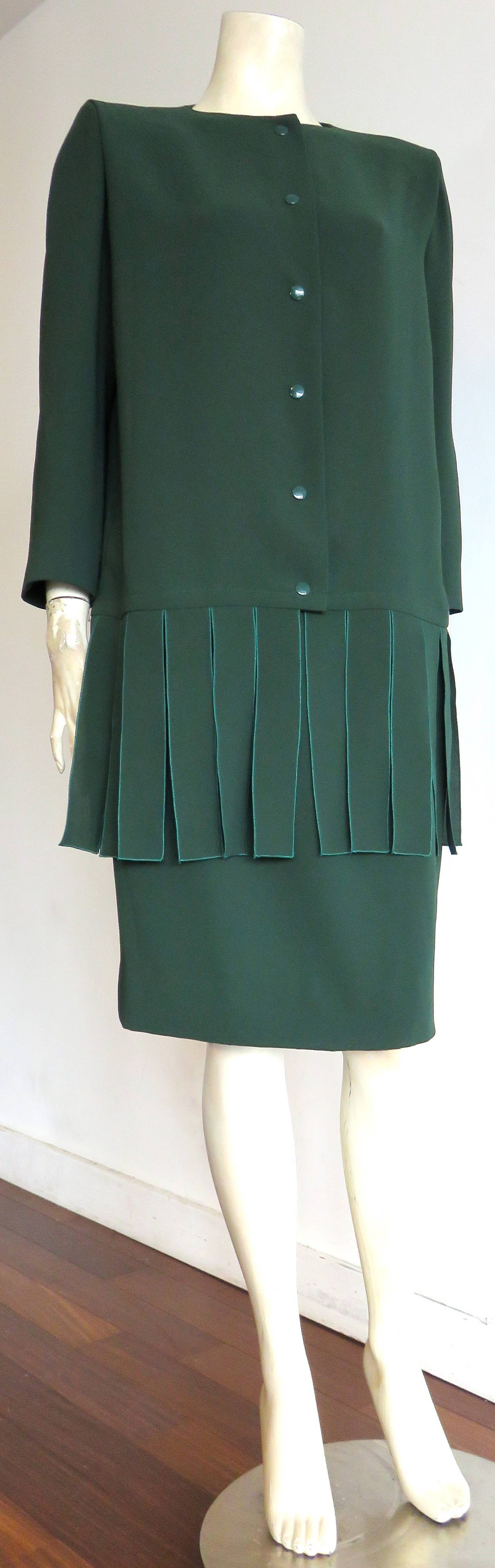 Never worn, 1970's PIERRE CARDIN PARIS Car-wash flap skirt suit.

Iconic, Pierre Cardin, flap-detail, skirt suit in forest green, silk-crepe fabrication.

Boxy-sihouette jacket with metal snap front closures, and flap-detail hem.

The matching