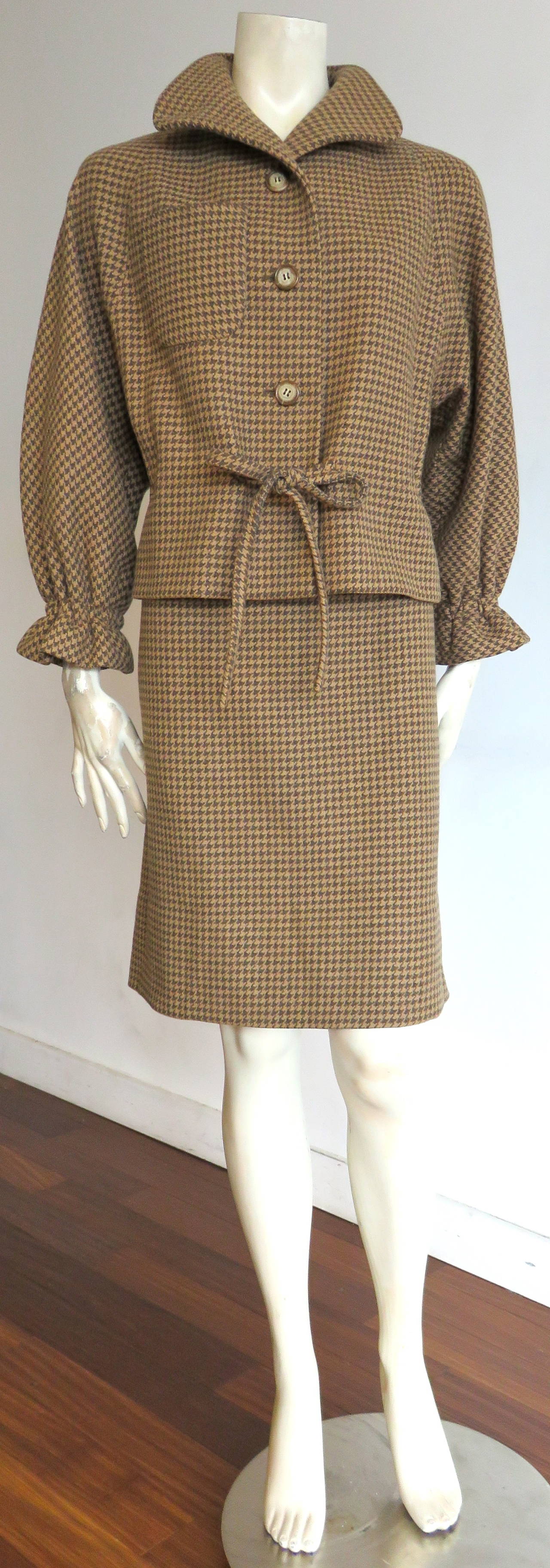 Excellent condition, early 1960's, PIERRE CARDIN PARIS wool houndstooth skirt suit.

This wonderful skirt suit features a lovely, tie-front jacket with volume shape sleeves, and flared, ruffle cuffs.  The jacket feats a patch pocket at the right