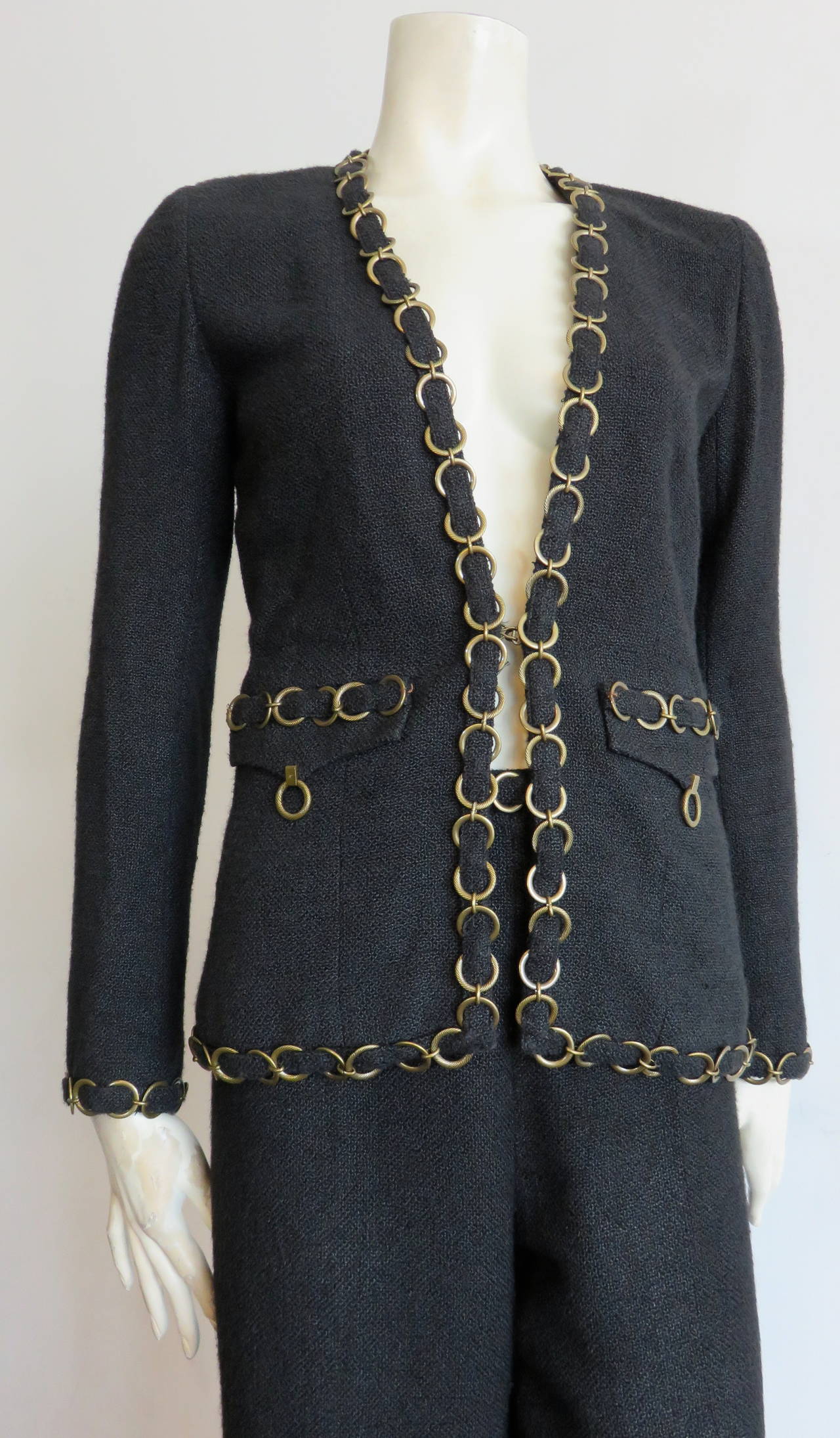 Great condition, CHANEL PARIS, metal ring-chain detail pant suit.

Fabulous, pant suit featuring large, brass, metal ring chain detailing interlaced with self-fabric binding.

Metal ring chains are logo engraved at the front flap pockets as