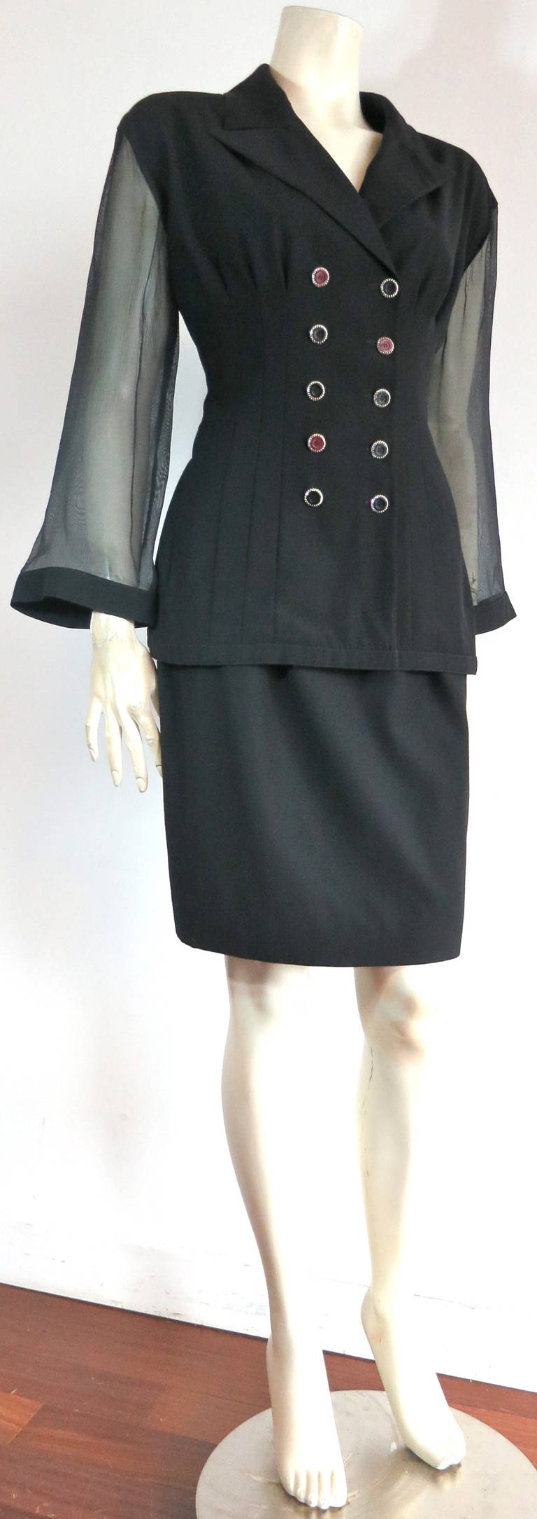Mint condition 1980's KARL LAGERFELD black skirt suit with sheer sleeves.

Made in France, as labeled.

Gorgeous black wool, two piece skirt suit. 

The jacket features four, vertical pleat-style seams at both front panels with ten button