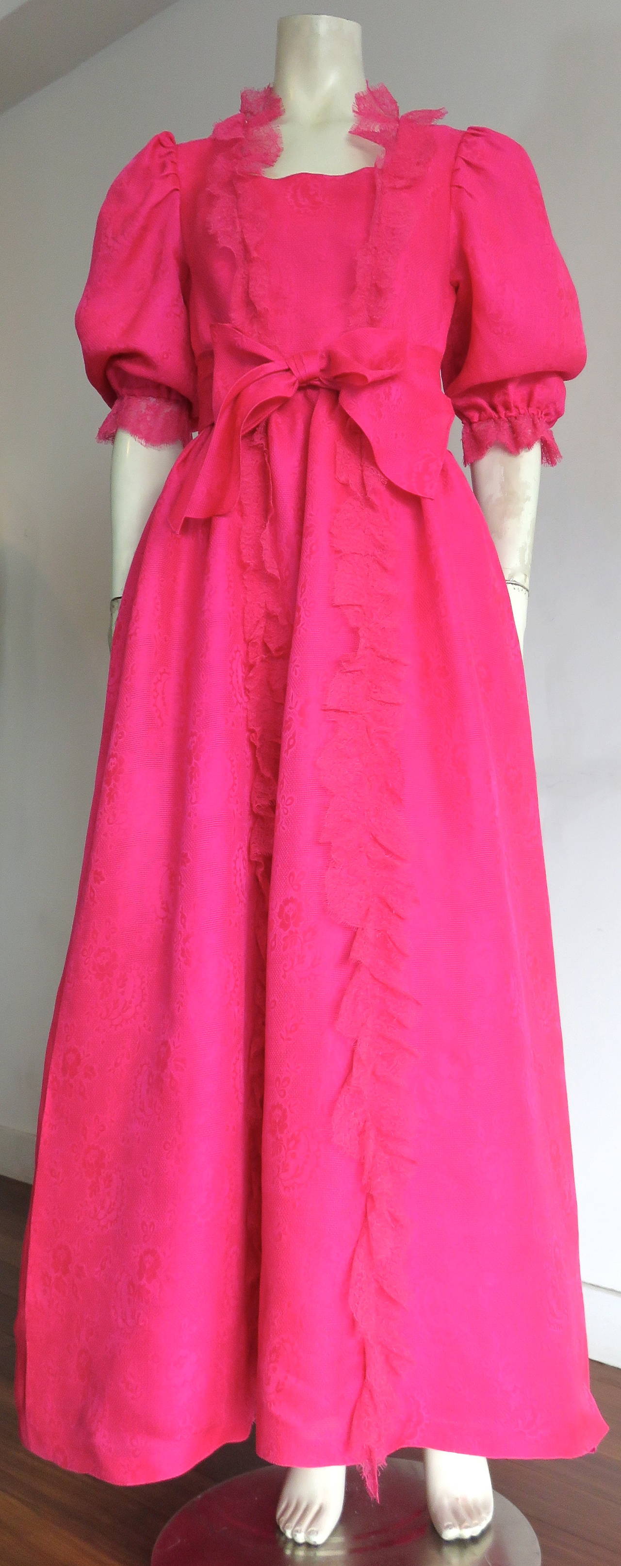 Excellent condition, 1970's, NINA RICCI PARIS, Haute pink silk evening gown.

This fabulous evening gown features luminous, silk jacquard fabrication in a beautiful, 'shocking pink', woven floral design.

The dress features floral lace trim with