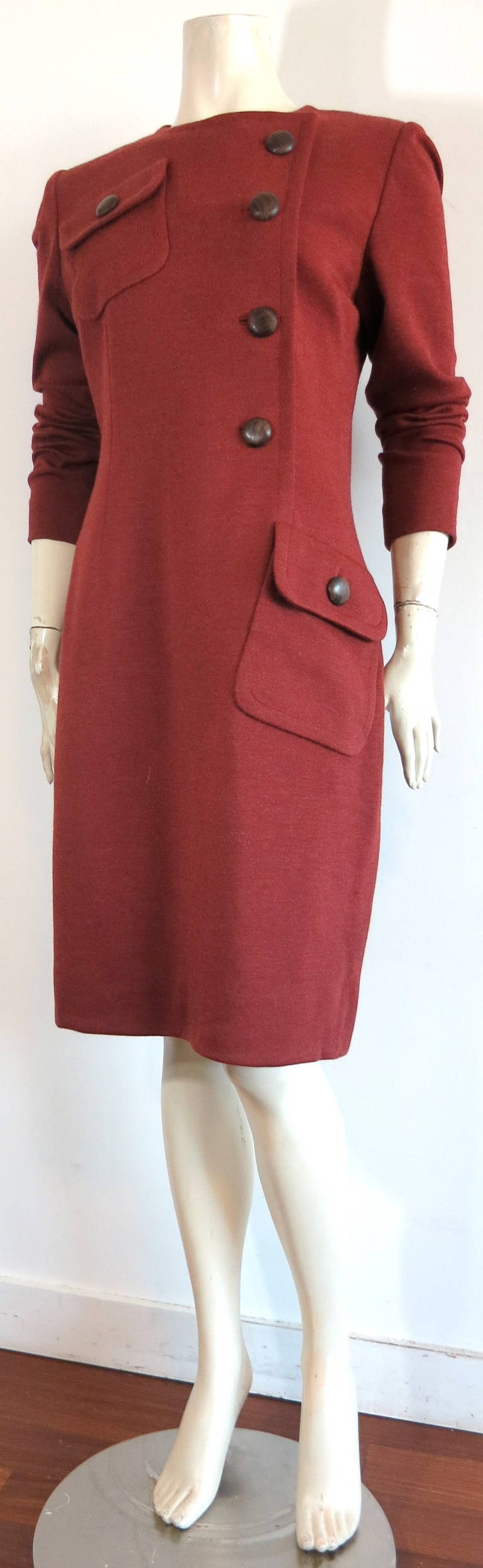 Mint condition 1980's GIVENCHY COUTURE Wool jersey day dress in dark orange/red color.

Asymmetrical front opening with large, wooden button closures.

Right chest, and left hip, flap pockets.

Center-back zipper entry.

Fully