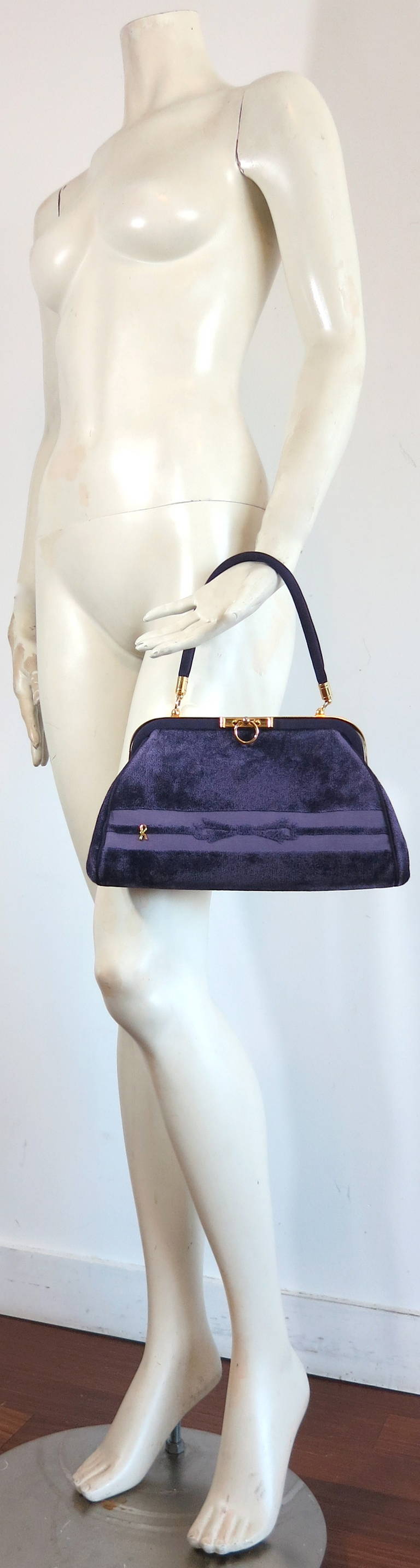 Excellent condition, vintage ROBERTA DI CAMERINO purple velvet purse.

Signature, cut velvet, bow front artwork with metal 'R' monogram logo front.

Polished gold finish metal hardwares with ring front opening at the top.  

The bag is opened