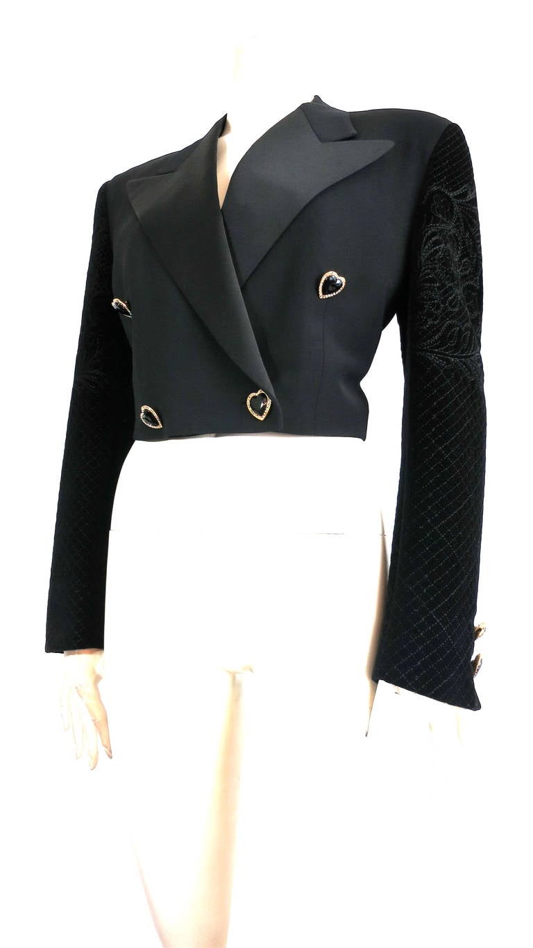 Excellent condition, 1980's GIANNI VERSACE COUTURE Embroidered tuxedo jacket.

This amazing tuxedo jacket features a cropped length silhouette with satin, peaked lapels, and embroidered velvet sleeves.

Heart shaped buttons, resin buttons at