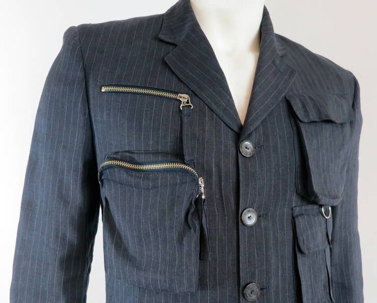 Excellent condition, 1990's JEAN-PAUL GAULTIER Men's, multi-pocket travel blazer jacket.

Amazing, bellow-style, pocket details with metal zipper closures, and and cloth pullers.  'D'-ring hardware at left chest.

Four-button front
