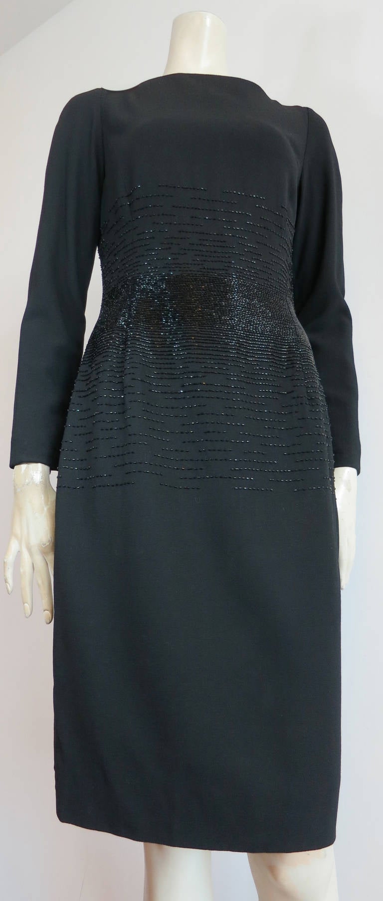 Excellent condition, 1990's OSCAR DE LA RENTA Beaded cocktail dress.

Compact, bugle beaded waist which goes up and down the torso in a linear, beaded pattern.  

Boat-neck silhouette.

Black crepe fabrication which is fully