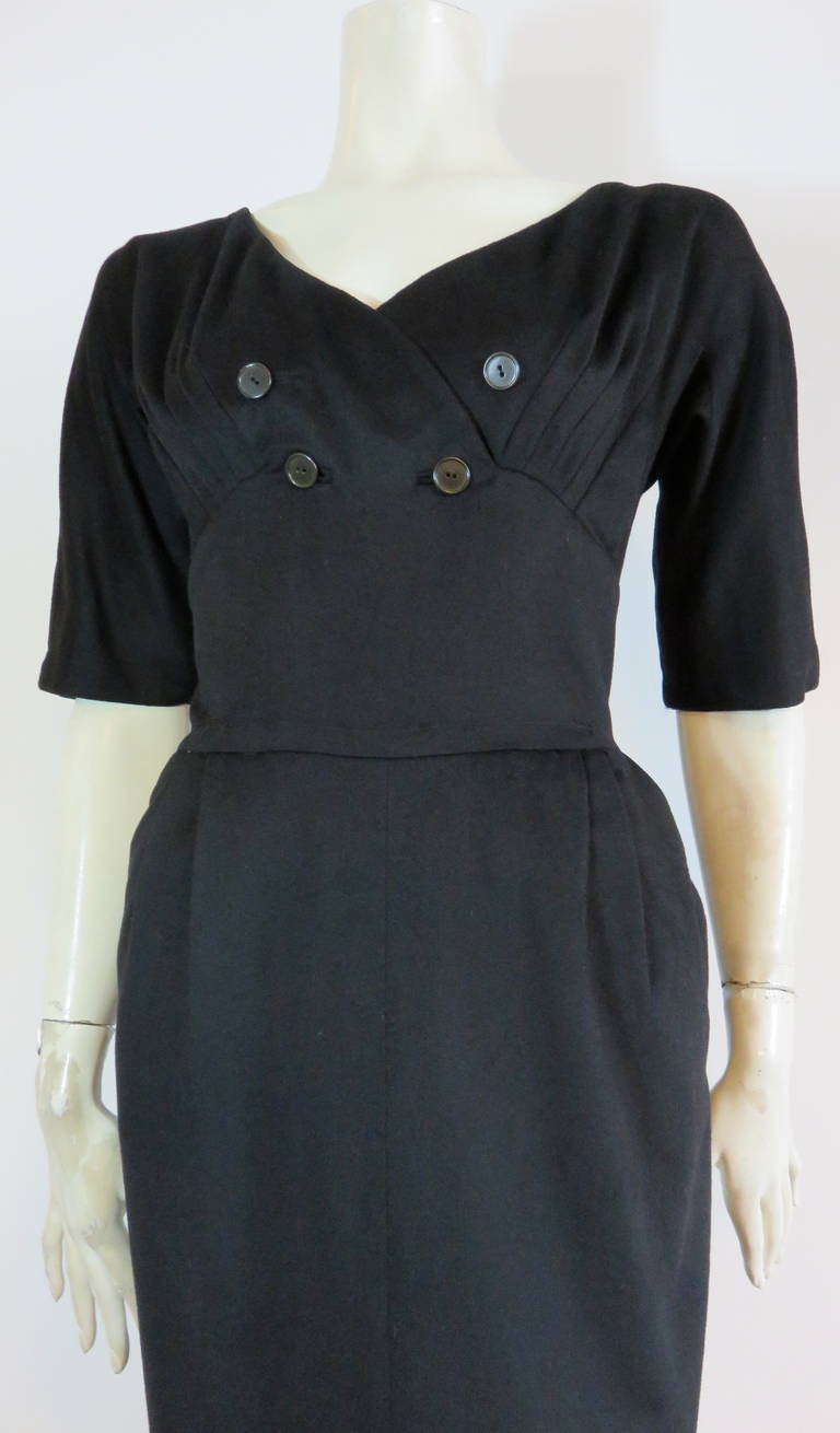 1950's HATTIE CARNEGIE Black wool & cashmere dress.

This lovely dress features a fitted waist silhouette with pleated bust detailing.  The front chest features double-breasted style buttons, and button holes.

Concealed side metal, 'Talon'