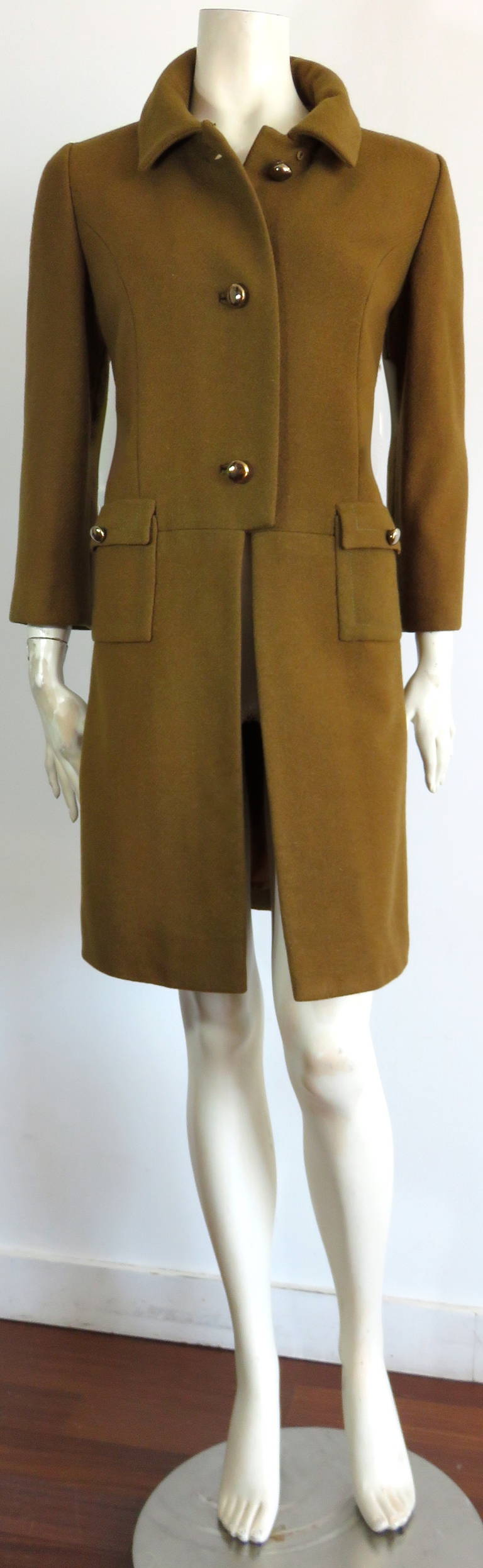 1950's FONTANA ROMA Olive wool coat.

This adorable coat was designed by the Fontana sisters during the 1950's in Rome, Italy.

The coat features brass metal button closures at the center-front opening, and the twin waist-level flap