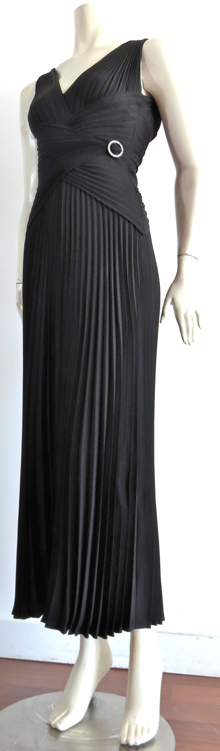 Excellent condition, 1980's LORIS AZZARO black, crystal pleated, evening dress.

This gorgeous dress was designed by Loris Azzaro in France, during the 1980's.

The radial, crystal pleats of the waist were constructed to have a gorgeous