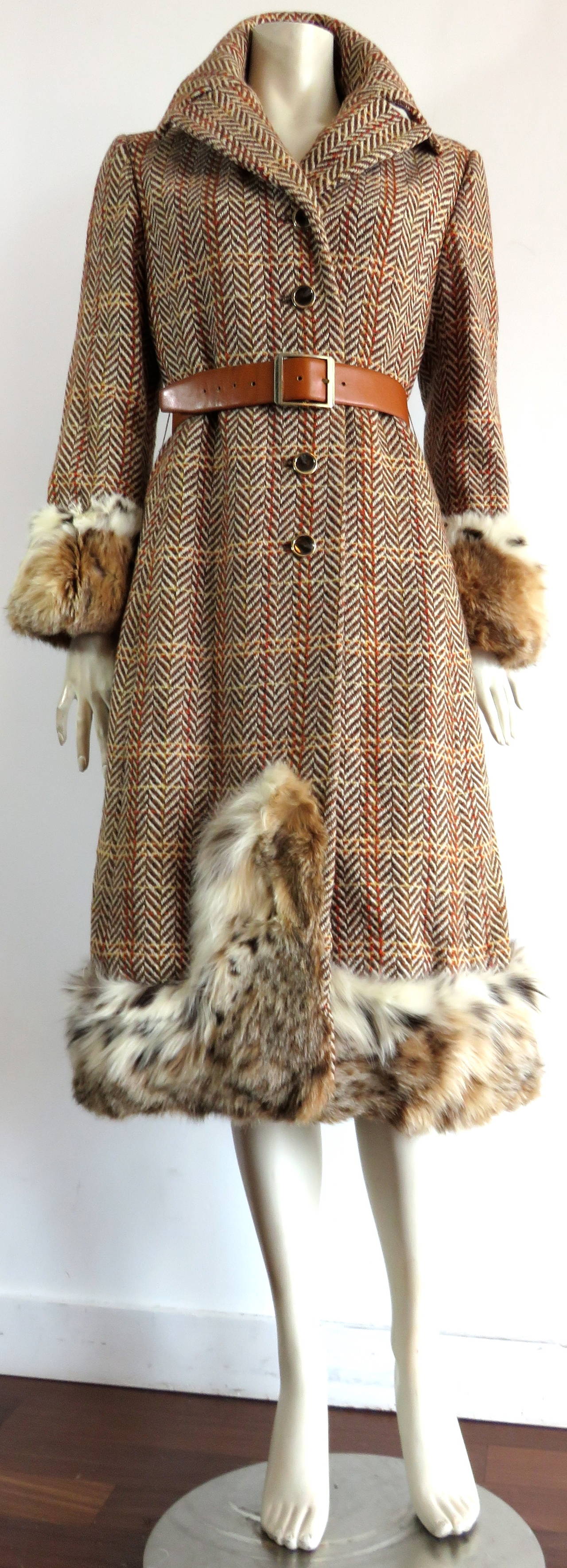 Vintage CHRISTIAN DIOR, wool tweed midi-coat with genuine Lynx fur detailing from Fall/Winter 1970. 

The same style coat was featured in the August 1970 issue of Harper's Bazzar magazine, as shown in the photo section.

The tan and brass belt