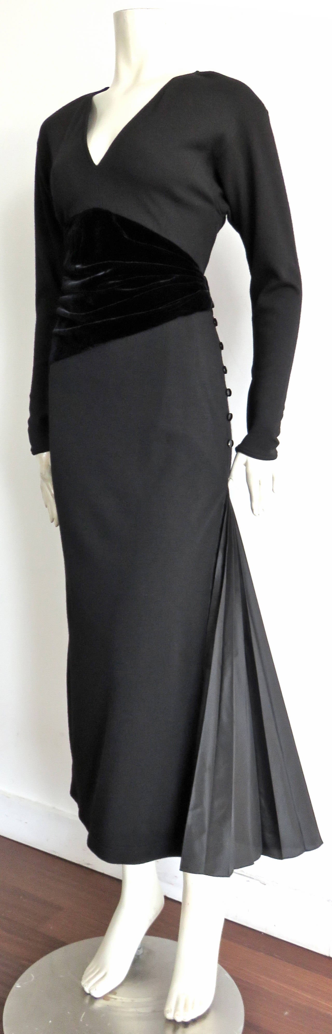Designed by Emanuel Ungaro in France during the 1980's, this stunning dress is made of black, wool knit jersey with, gathered, silk velvet inset detail at the waist.  The bottom left of the dress features a pleated, silk taffeta gusset detail  that