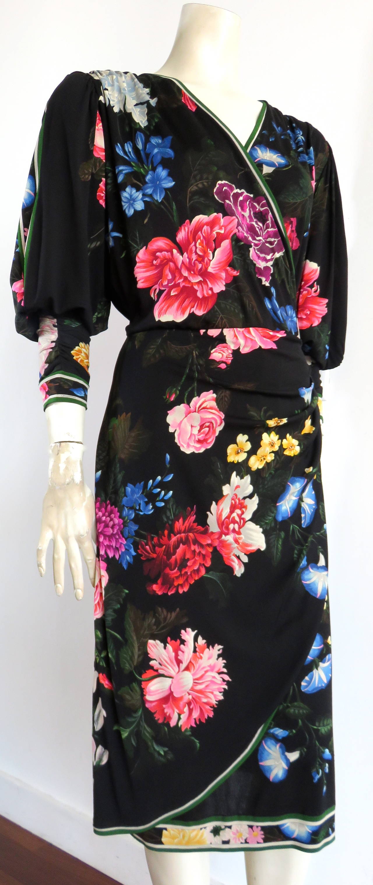 1983 LEONARD PARIS, silk, knit jersey dress with beautiful, painted floral artwork.

This gorgeous dress features a black background with multi-color, painted floral artworks.  The dress also features the signature, Leonard-style, striped border