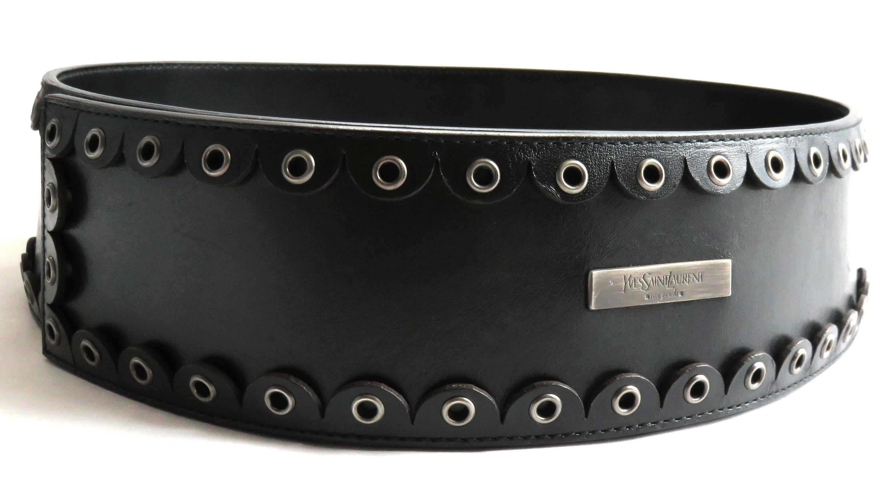 Excellent condition, 2001, YVES SAINT LAURENT by Tom Ford, wide leather runway belt.

Iconic runway belt in dark brown leather with scalloped edging, and metal grommets at top and bottom edges.

Logo engraved, metal plate at