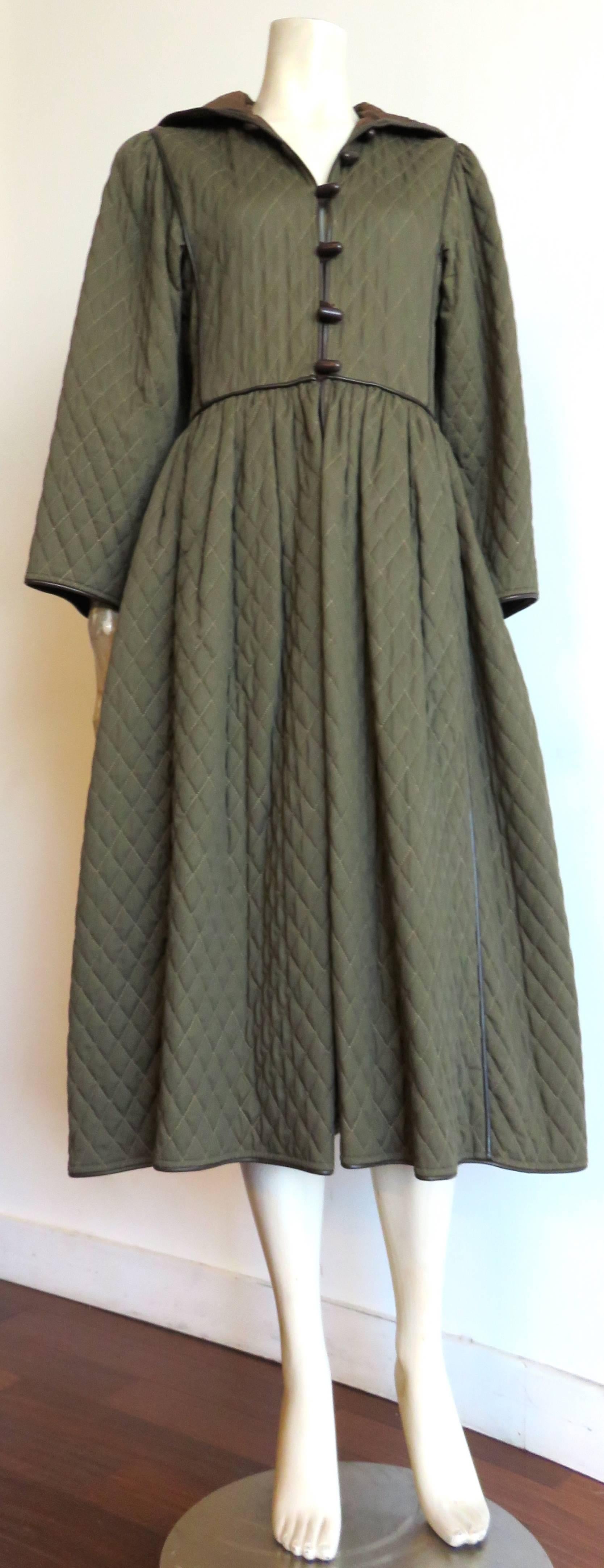Great condition, 1970's SAINT LAURENT Iconic, diamond-quilted coat dress in olive green with dark brown leather piping seaming detailing throughout.

Lightly padded.

Fitted waistline with a flared, skirt silhouette.

Dark brown, toggle front,