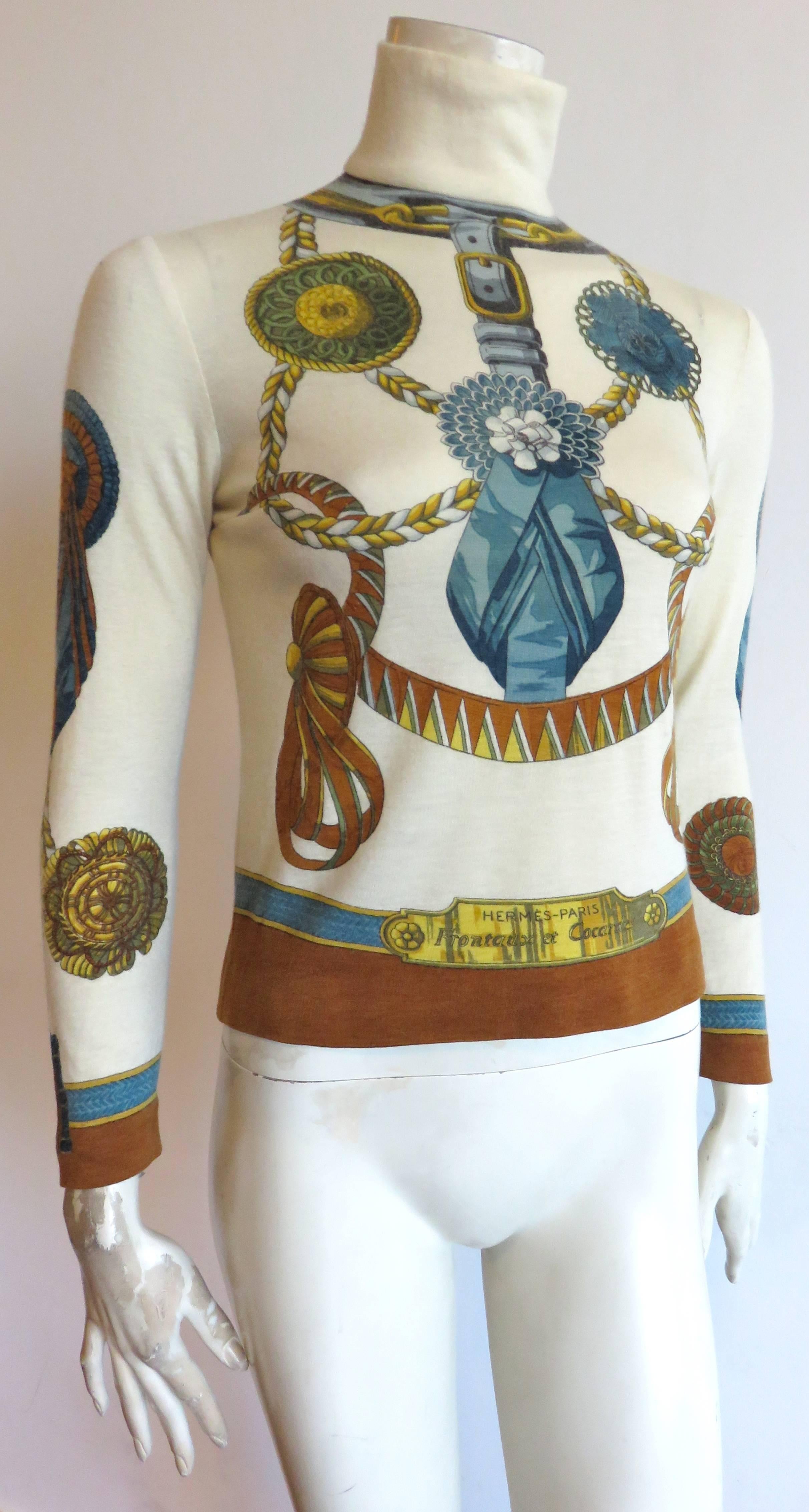 1980's HERMES PARIS Trompe l'oeil cashmere sweater.

Very soft, turtle-neck sweater featuring trompe l'oeil artwork decorations at front, back, and sleeves.

Prominent, 'Hermes' engraved, trompe l'oeil plates at front and back.

Center-back