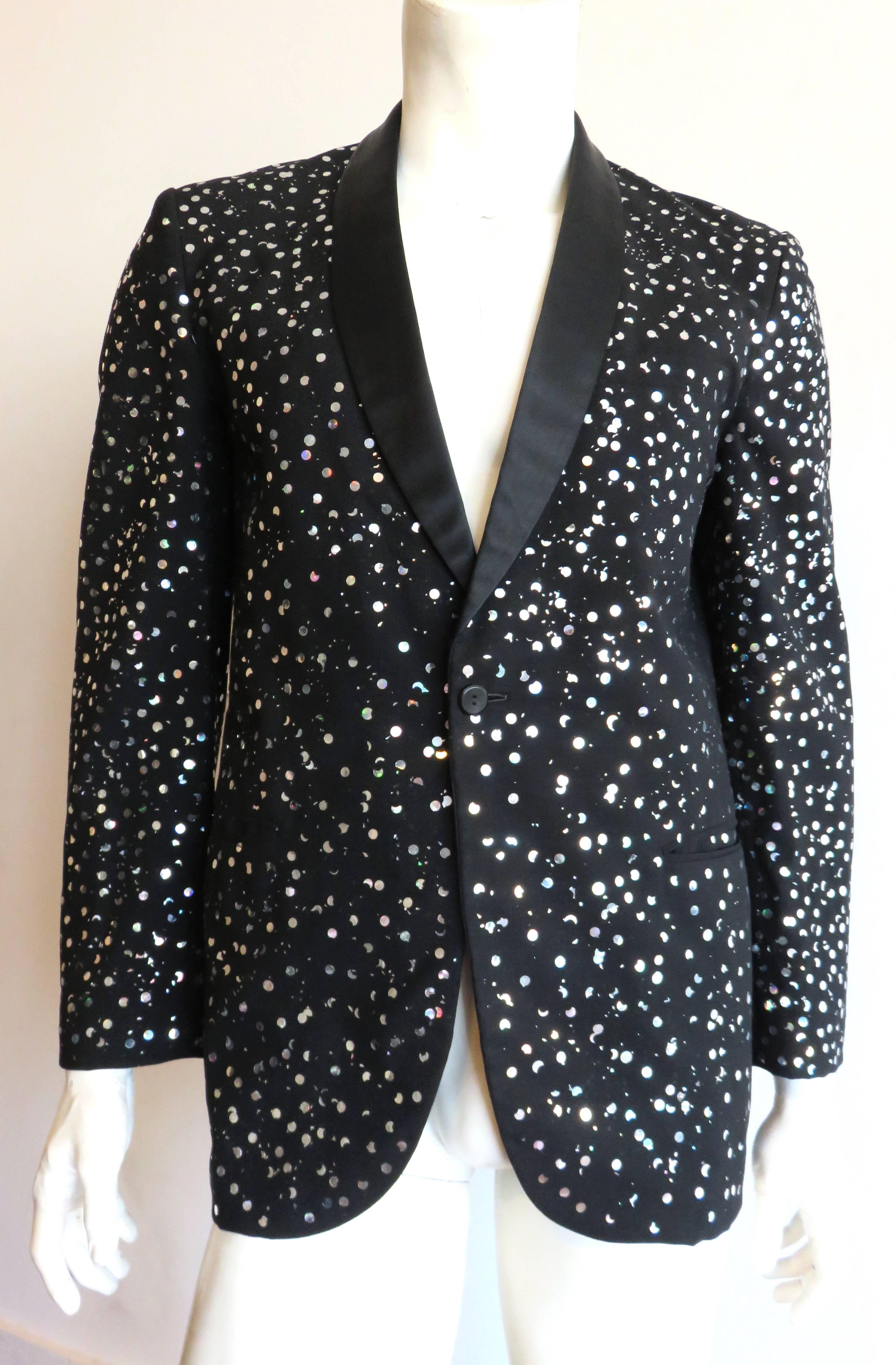 Amazing, 1980's, men's, hologram confetti, tuxedo jacket.

Single-button front closure with satin lapels, and twin, welt pockets at the waist.

Fully lined.

True, rainbow-reflective, hologram, confetti embellishment.