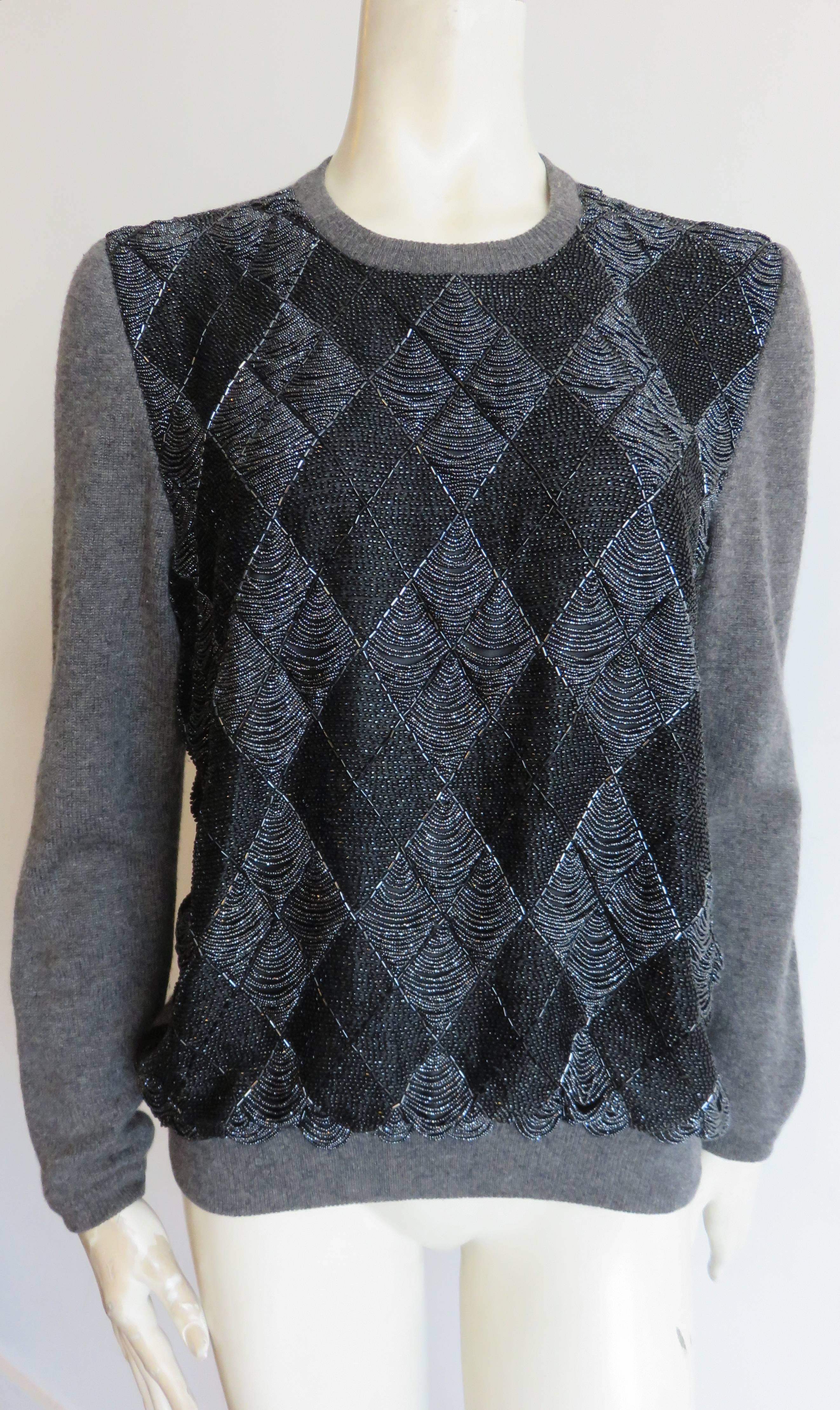 Excellent condition, 1980's, hand-beaded argyle sweater, attributed to Jean-Paul Gaultier.

Gray wool/cashmere, knit body with black, and gray, caviar beading at front panel.

Concealed, snap back placket at center-back neck.

In excellent