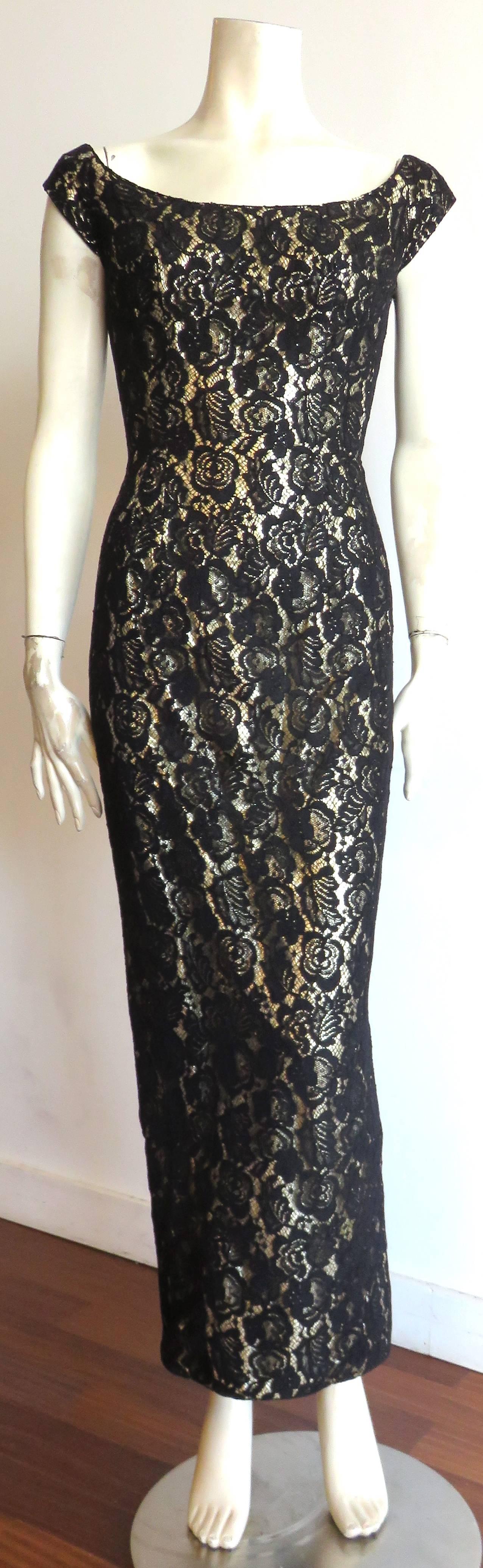 Excellent condition, 1960's MR. BLACKWELL CUSTOM, Gold lame with black lace overlay evening dress.

Sexy, body-con silhouette.

'V' shaped back neckline with mini-bow tie detail at center-back top zipper.

Floral, black lace atop, metallic