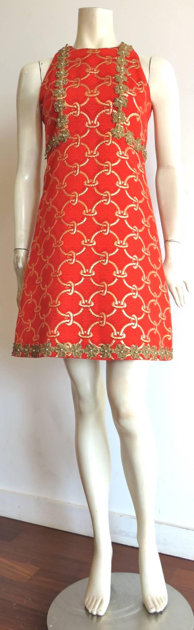 Gorgeous, early 1960's OSCAR DE LA RENTA Embellished brocade cocktail dress.

Thick, brocade tapestry weave fabrication featuring metallic gold, ring chain artwork atop 'poppy' (dark orange/red tone) ground.

Metal bullion floral embellishments
