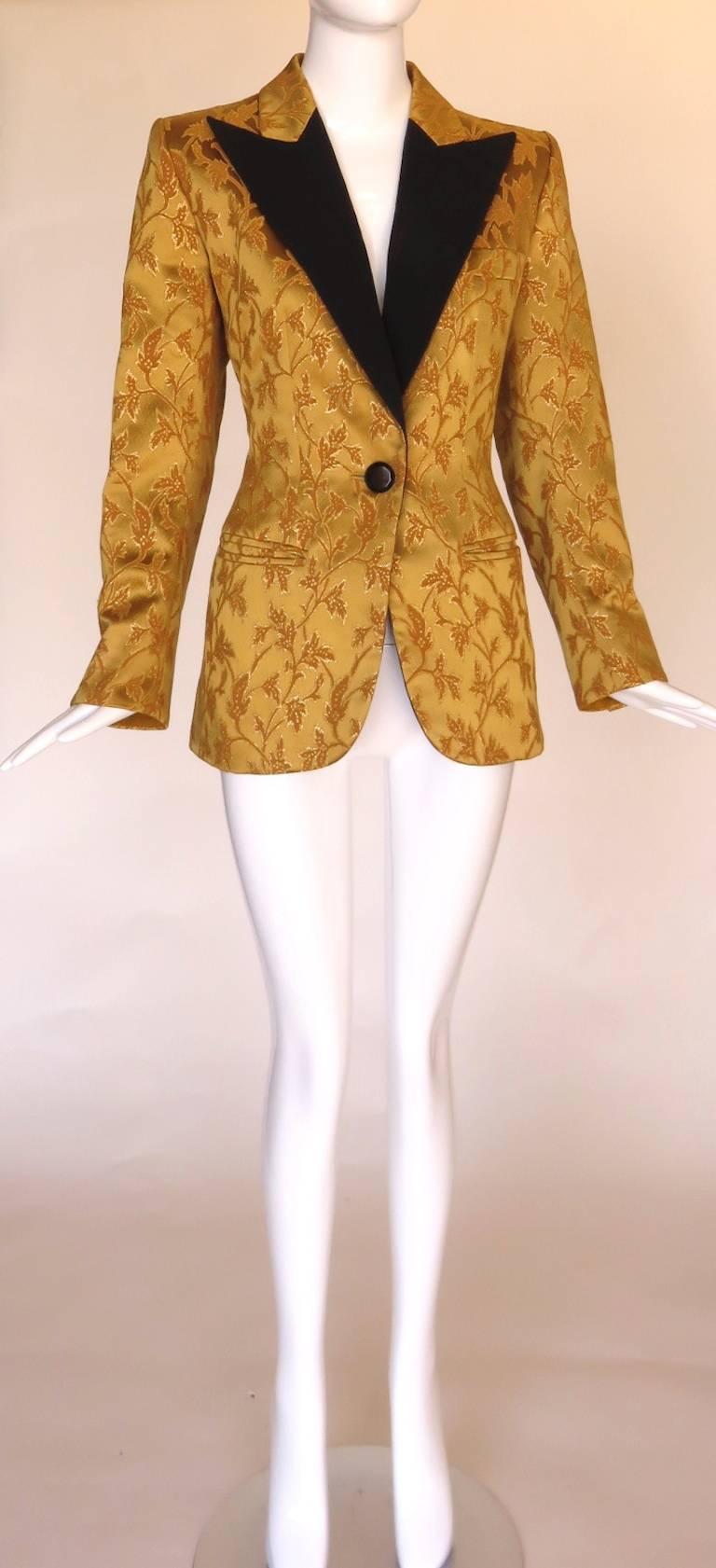 1990's YVES SAINT LAURENT Rive Gauche women's, golden brocade tuxedo jacket.

Golden, satin-face ground fabric with metallic, leaf jacquard patterning.

Contrast, black moire, peak lapels with black, onyx-style buttons.

Single button front